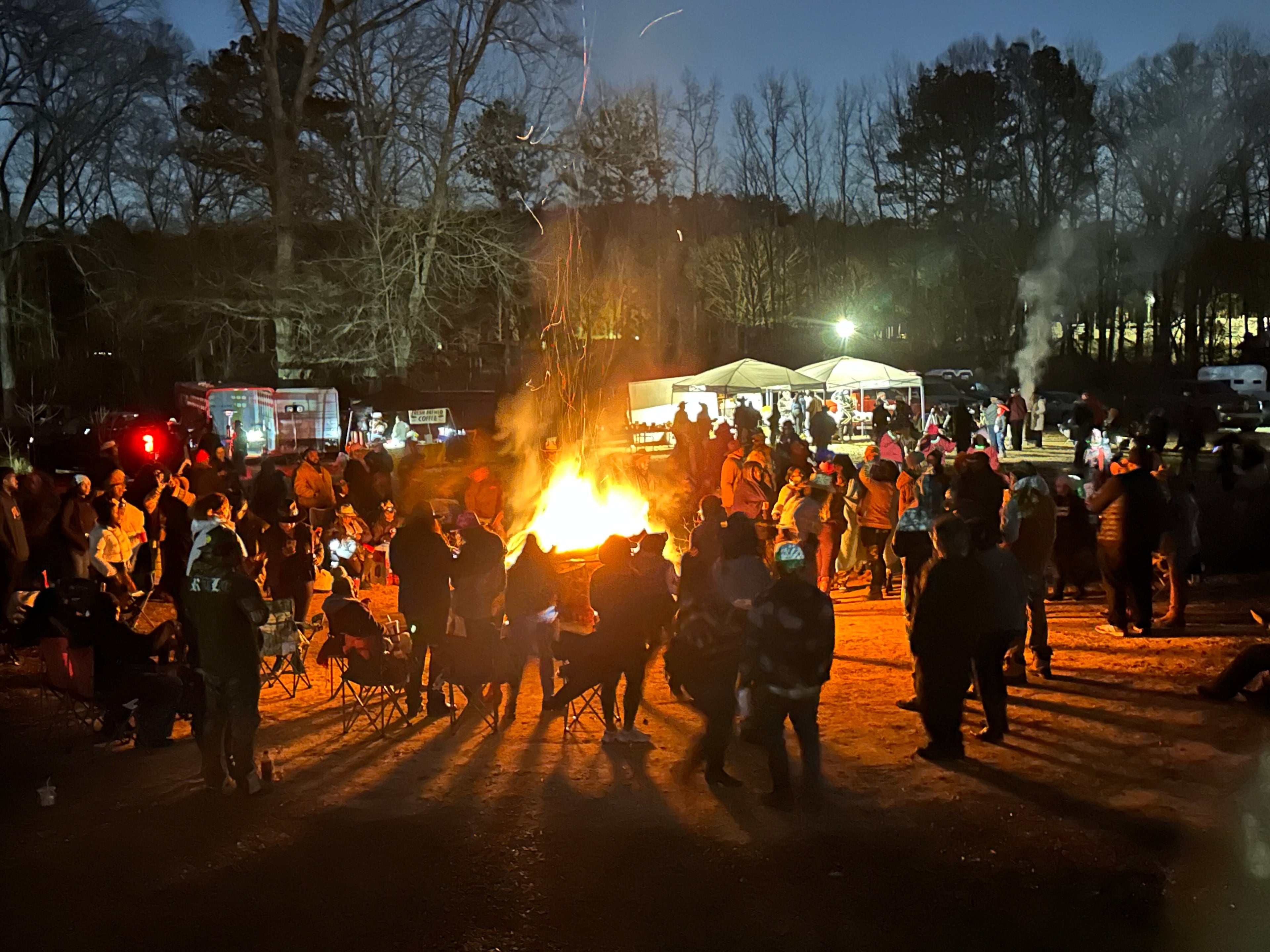 Participants in a trail ride hosted by the group Cowboys & Creatives gather around a bonfire in April 2025.