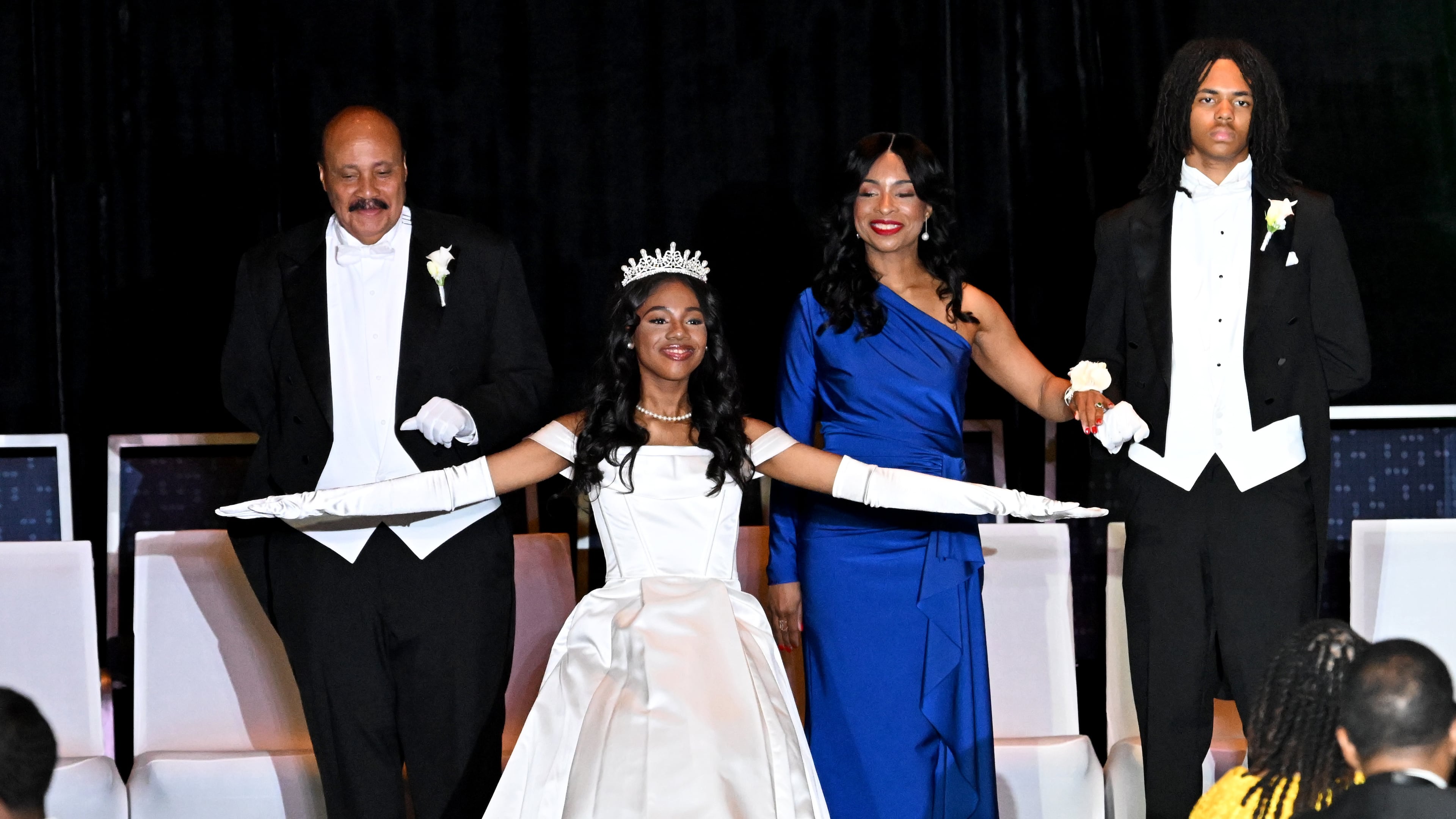 Debutante Yolanda Renee King is recognized as her parents Arndrea and Martin Luther King III and junior escort Brandon Coleman (right) stand behind her during the 2026 Pink Cultured Pearls Cotillion at the Georgia International Convention Center on March 29, 2026 in Atlanta. (Hyosub Shin/AJC)