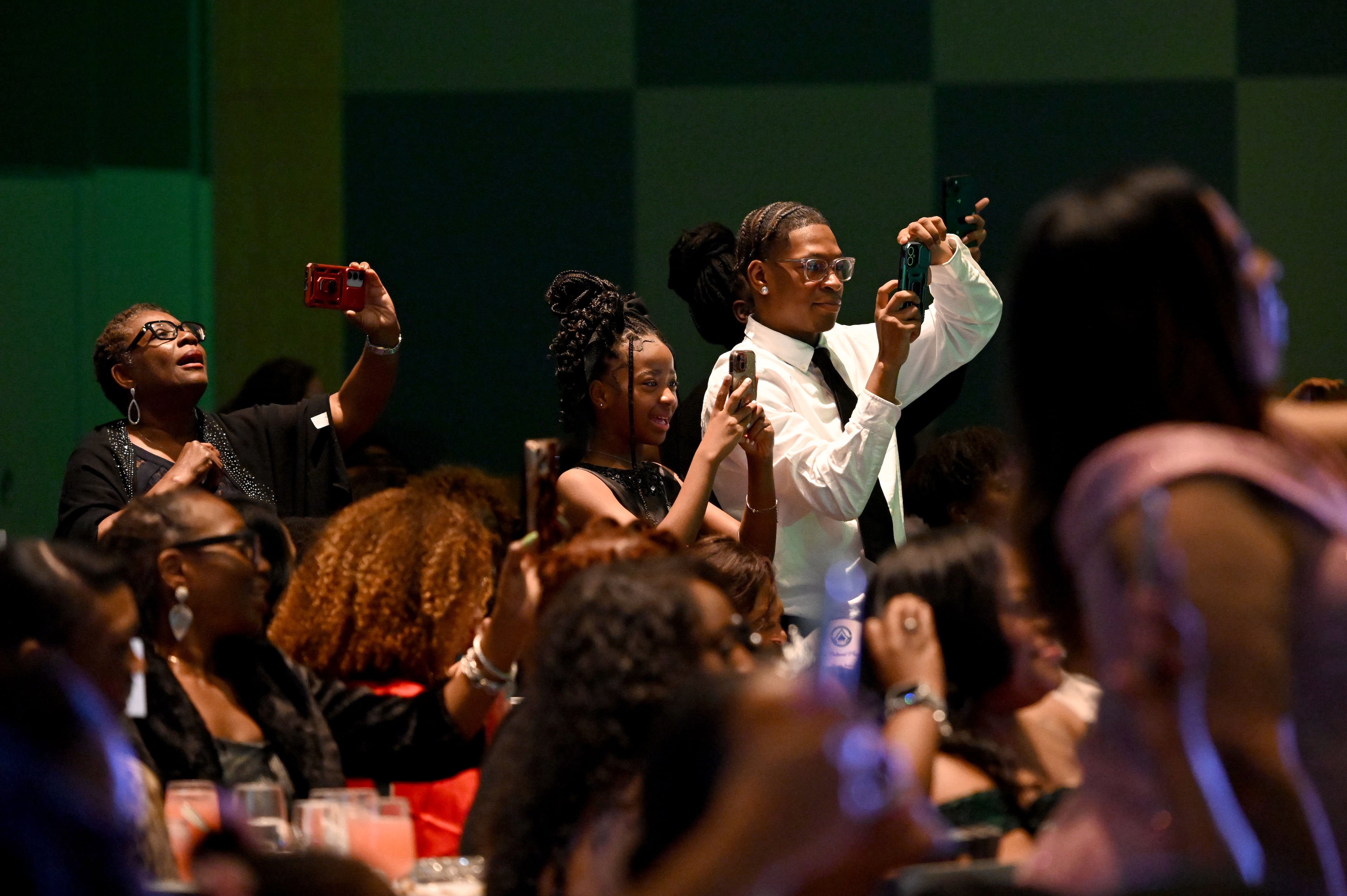 Guests hold their smartphones to take photos during the 2026 Pink Cultured Pearls Cotillion. (Hyosub Shin/AJC)
