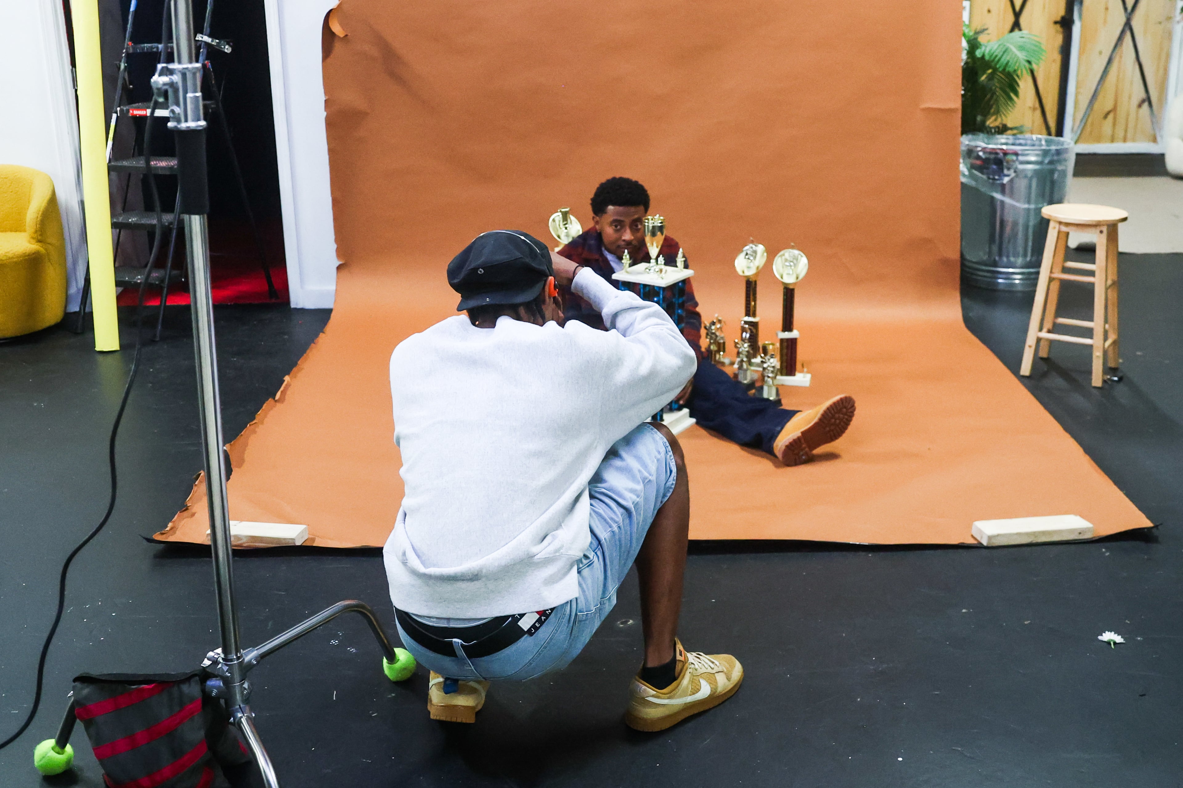 Photographer Quality Lenz, whose legal name is Jaylon Cooper, photographs rapper Deante Hitchcock at Area 412 Photo Studio in Atlanta. Cooper says he prefers shooting with film instead of digital cameras. (Abbey Cutrer/AJC)