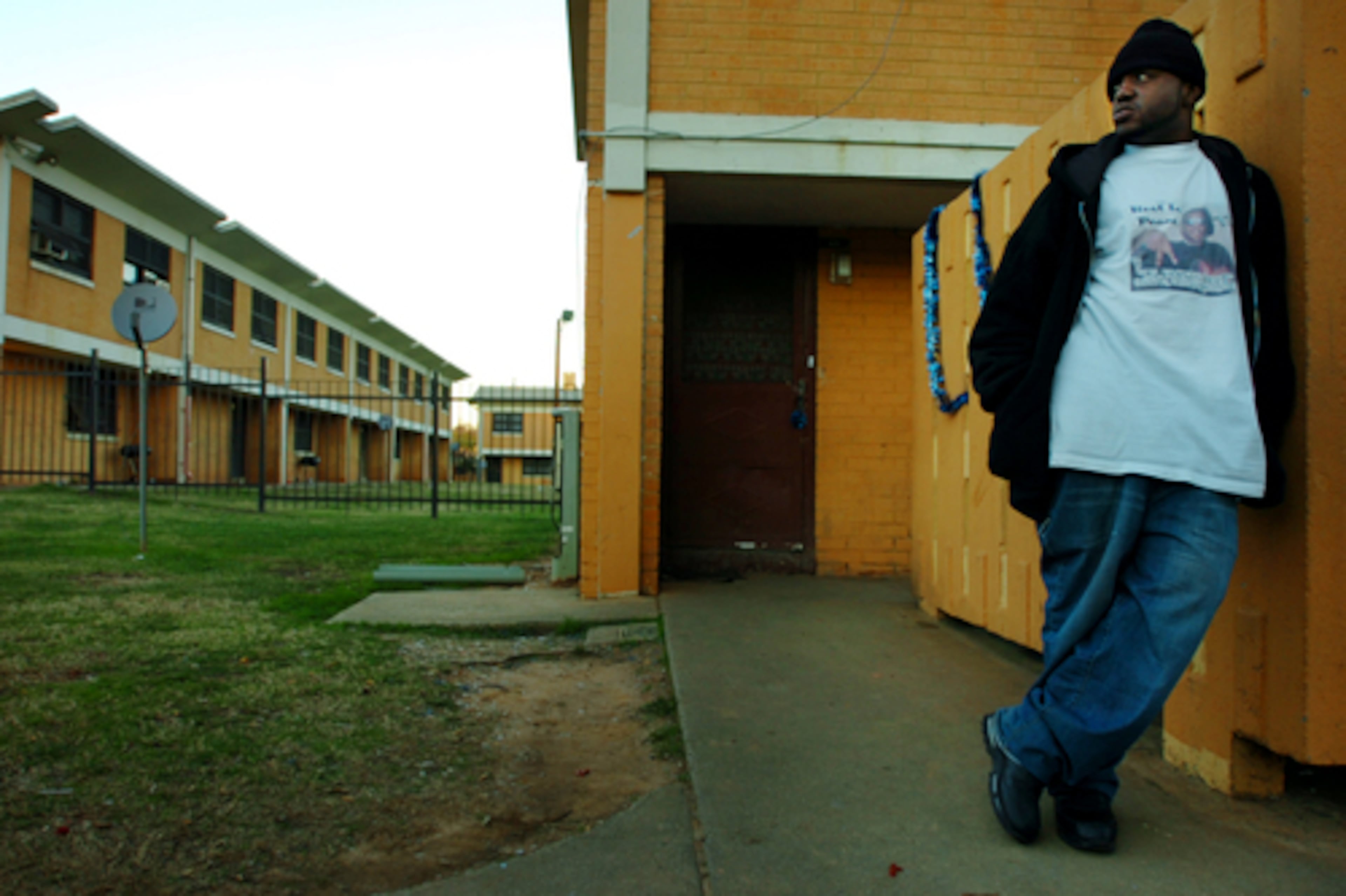 In this 2020 file photo, Mario Evans, 23, wears a shirt for his friend who was killed at the former Bowen Homes housing project in Atlanta. Since the mid-1990s, the Atlanta Housing Authority has been on a mission to wipe out concentrated poverty by tearing down housing projects and replacing them with mixed-income developments. (Elissa Eubanks/AJC)
