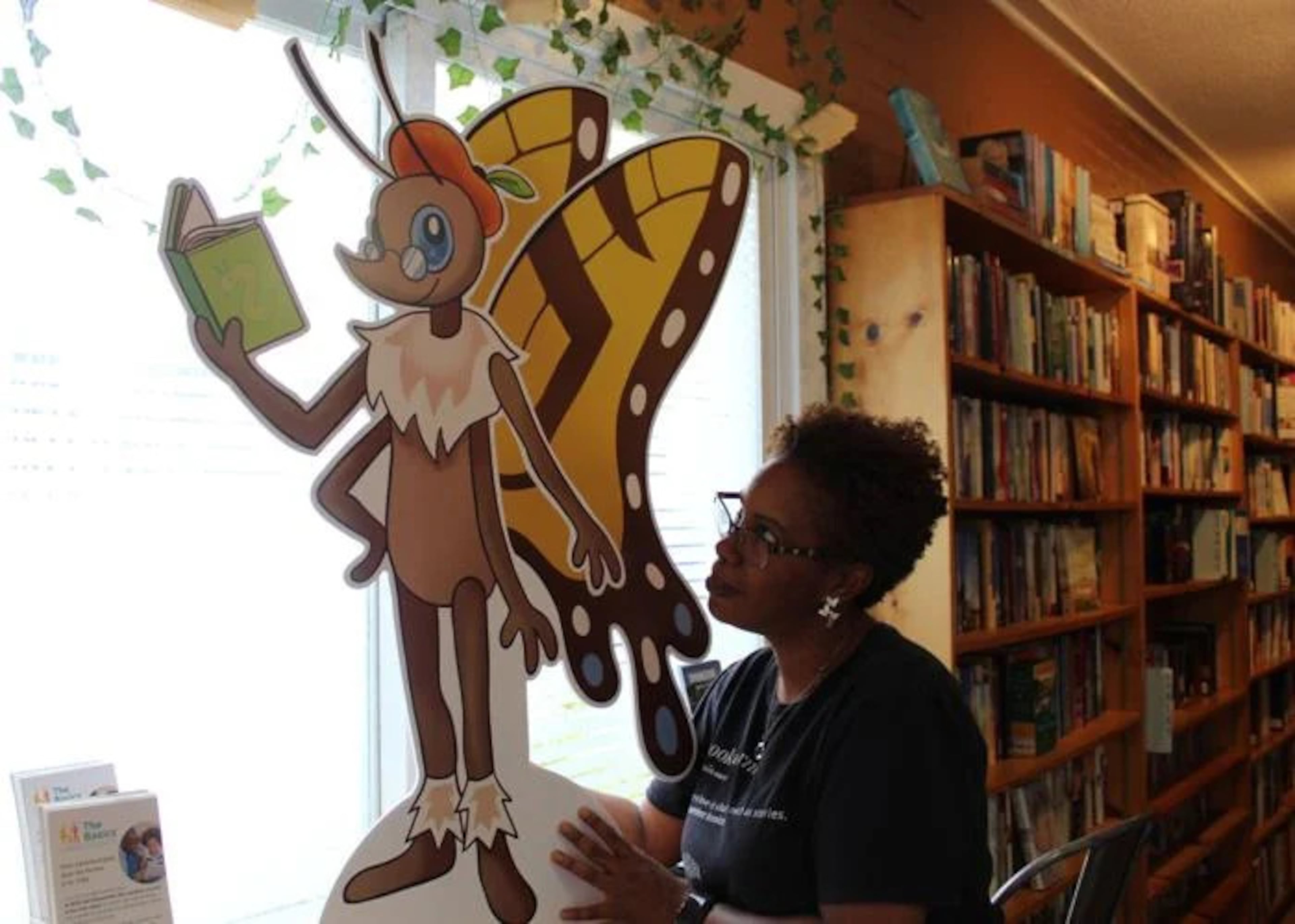 Julia Davis, owner of the Book Worm in Powder Springs, and the book fair mascot Paige Turner. Paige Turner is a butterfly with a peach beret, in case you were wondering. (Courtesy of Joe Adgie)