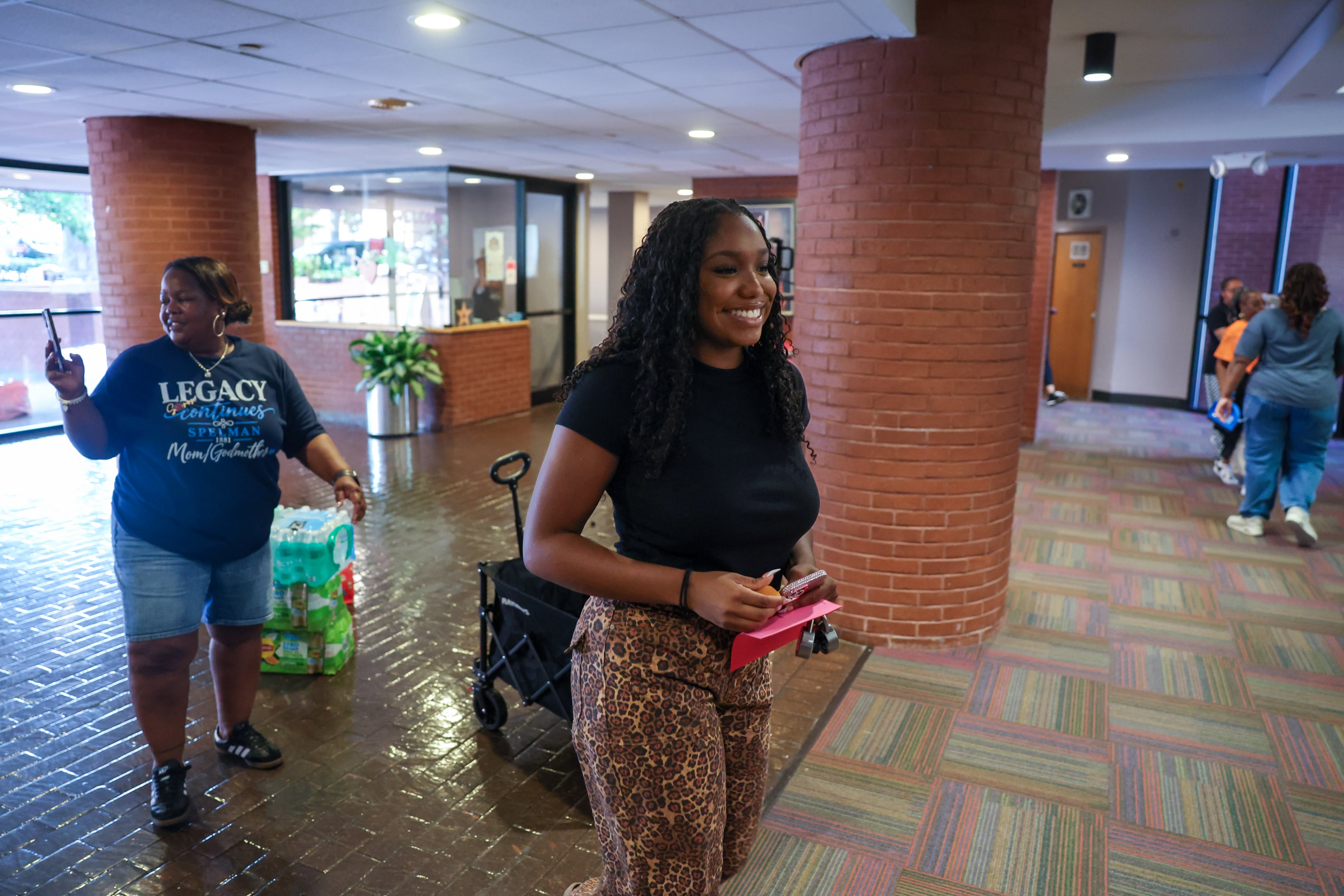 First-year honors student Brooke Spiva, followed by her godmother Shaunté Parker, moves into The Donald and Isabel Stewart Living-Learning Center at Spelman College in Atlanta on Aug. 11, 2026. (Arvin Temkar/AJC)