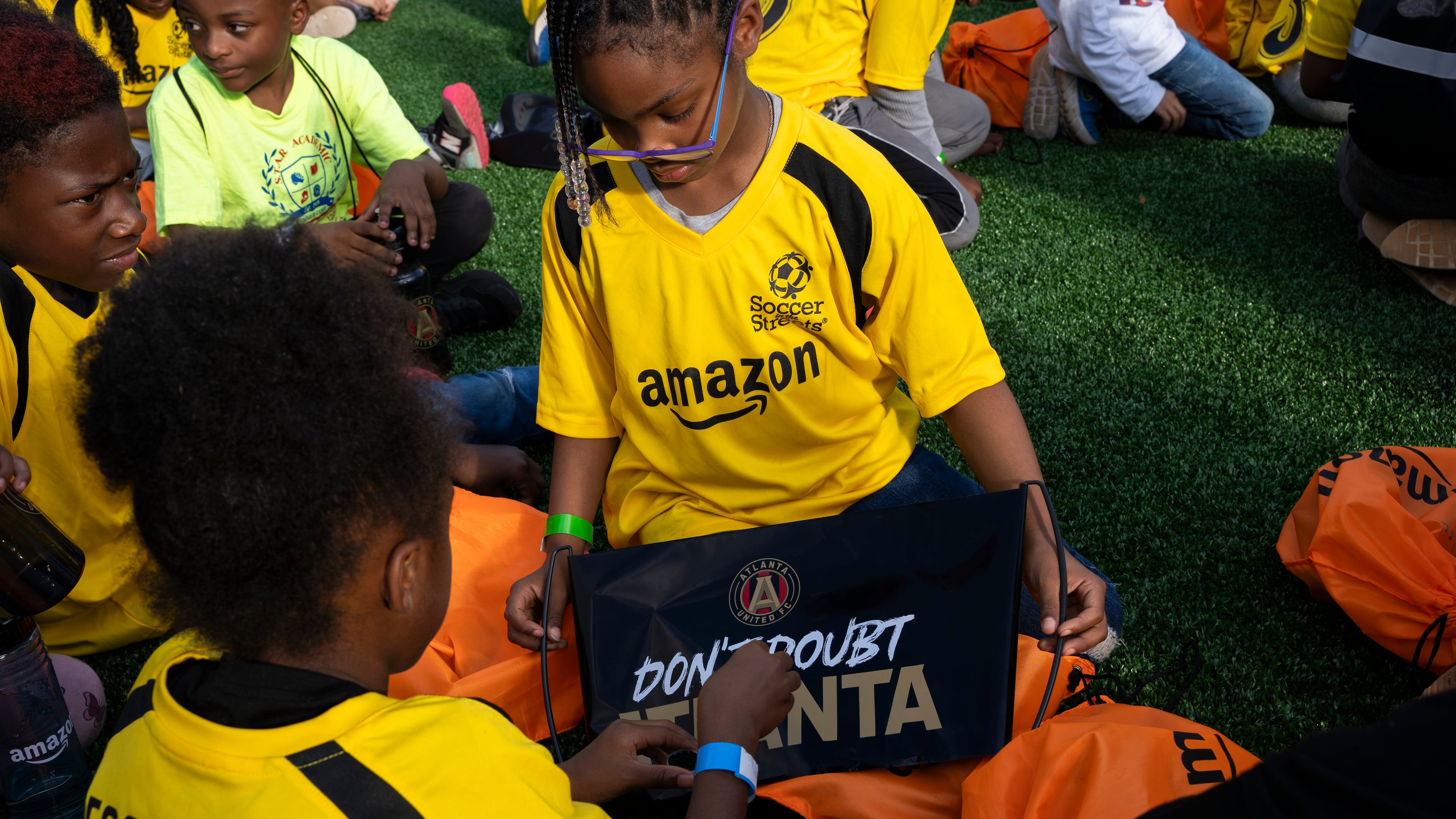 Kids play while speakers present Soccer in the Streets' new field at the East Lake MARTA station in Atlanta, 2023. (Olivia Bowdoin for the AJC).