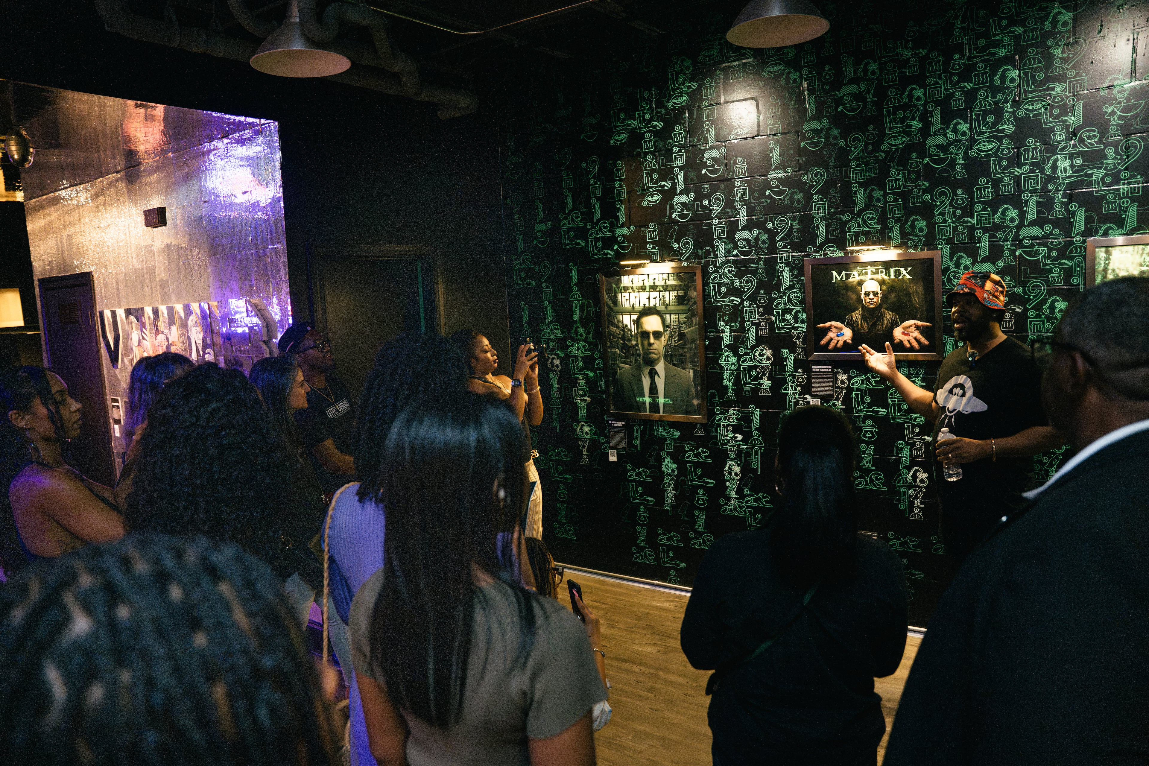 Artist Fabian Williams, right, leads visitors through “Mothership Sirius B” during a preview of the exhibit on Aug. 12, 2026, in Atlanta. Williams created the immersive experience with his wife, Sindy Guerrero-Williams, to explore Black history, science fiction and possible futures. (Olivia Bowdoin/AJC)