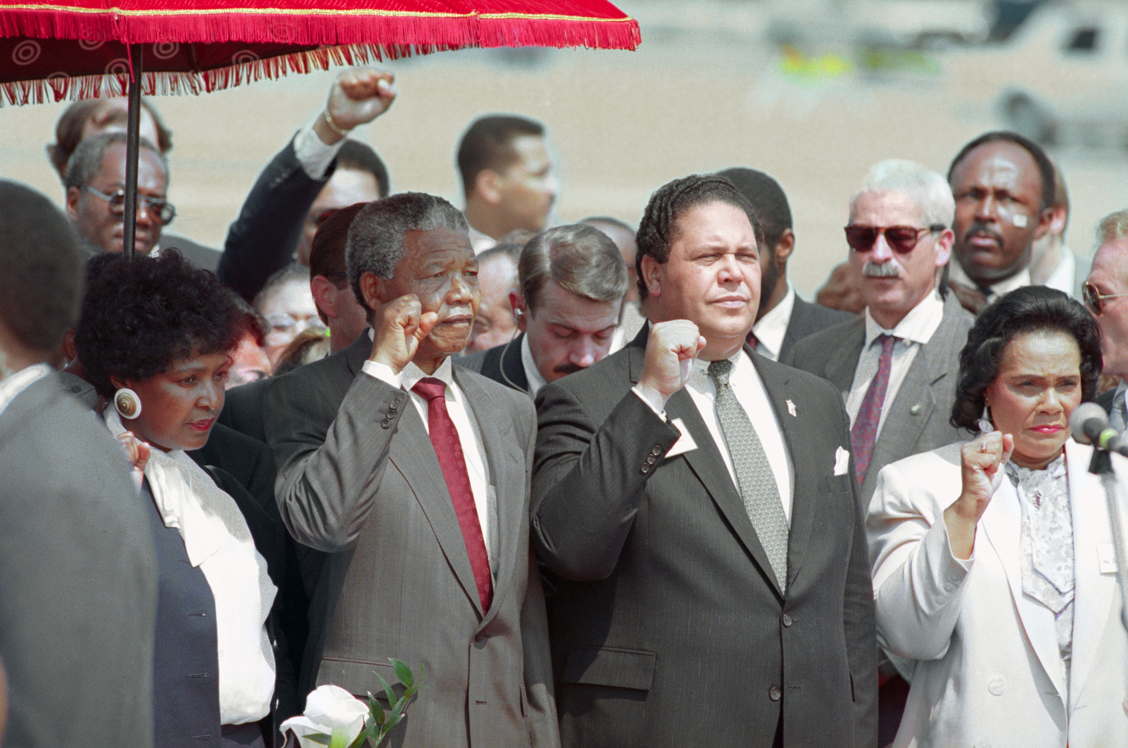 Former Atlanta Mayor Maynard Jackson (front row, second from right) and Coretta Scott King (right), widow of the Rev. Martin Luther King Jr., join Nelson Mandela (second from left) in holding up clenched fists during the playing of the anthem of Mandela's African National Congress on Mandela's arrival in Atlanta in 1990. (Bettmann Archive)