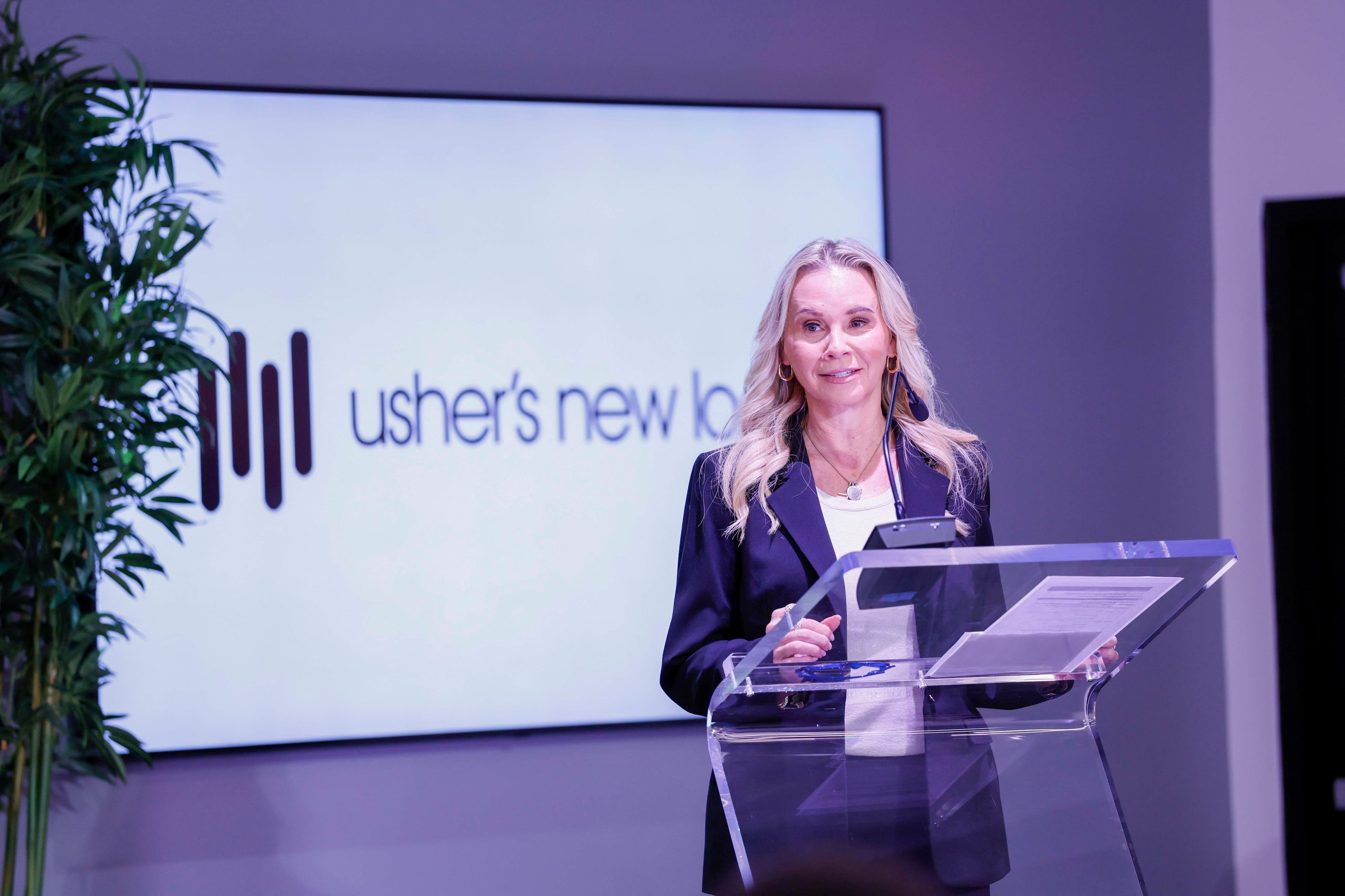 Chair of the Usher’s New Look, Cammie Rice, speaks to attendees at the Russell Innovation Center for Entrepreneurs on Thursday, Aug. 13, 2026, when the nonprofit introduced the three new employees. (Miguel Martinez/AJC)