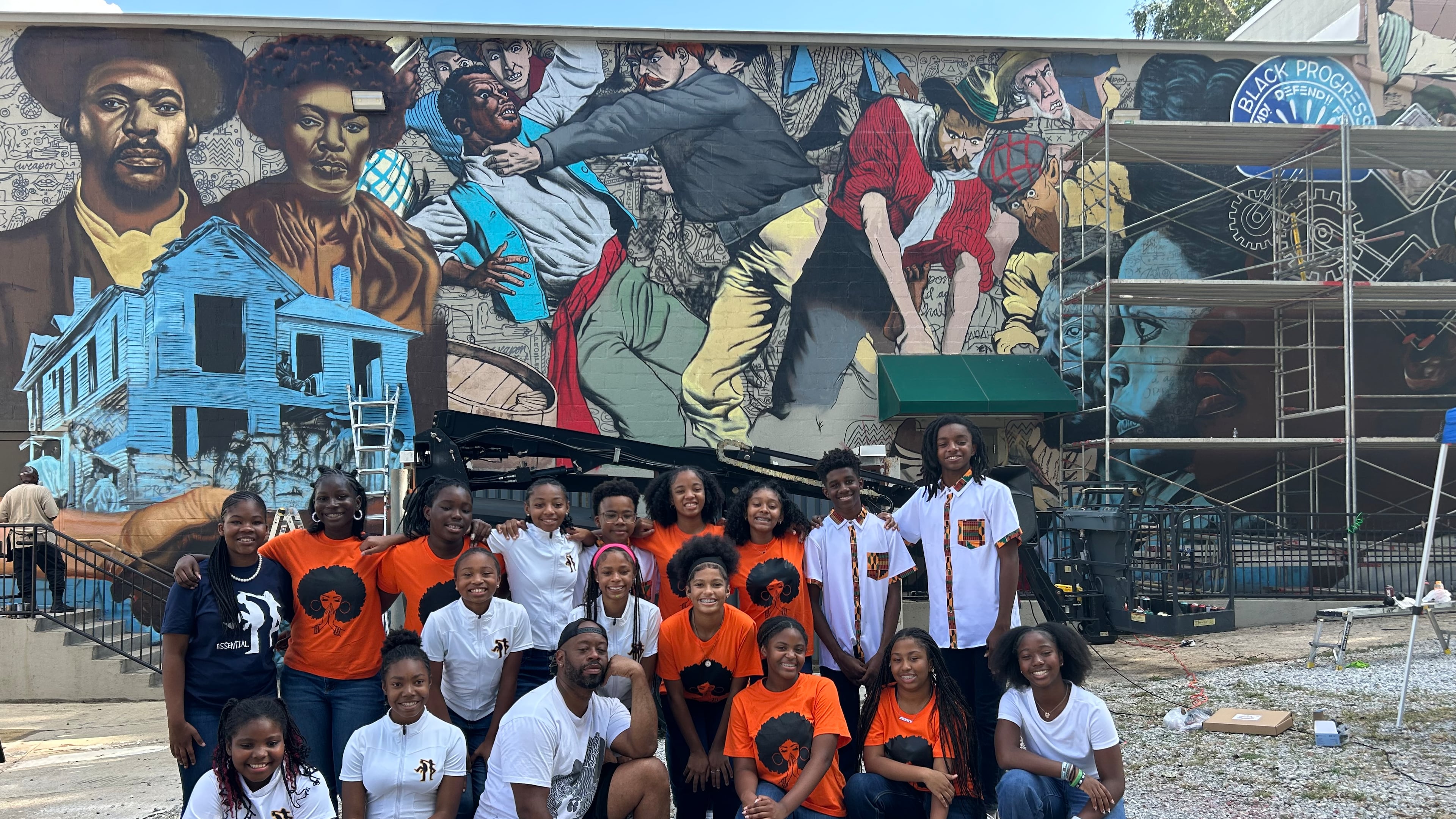 Artist Fabian Williams was joined by members of the Ron Clark Academy step team in front of his mural at Focused Community Strategies. (Courtesy of the National Center for Civil and Human Rights)