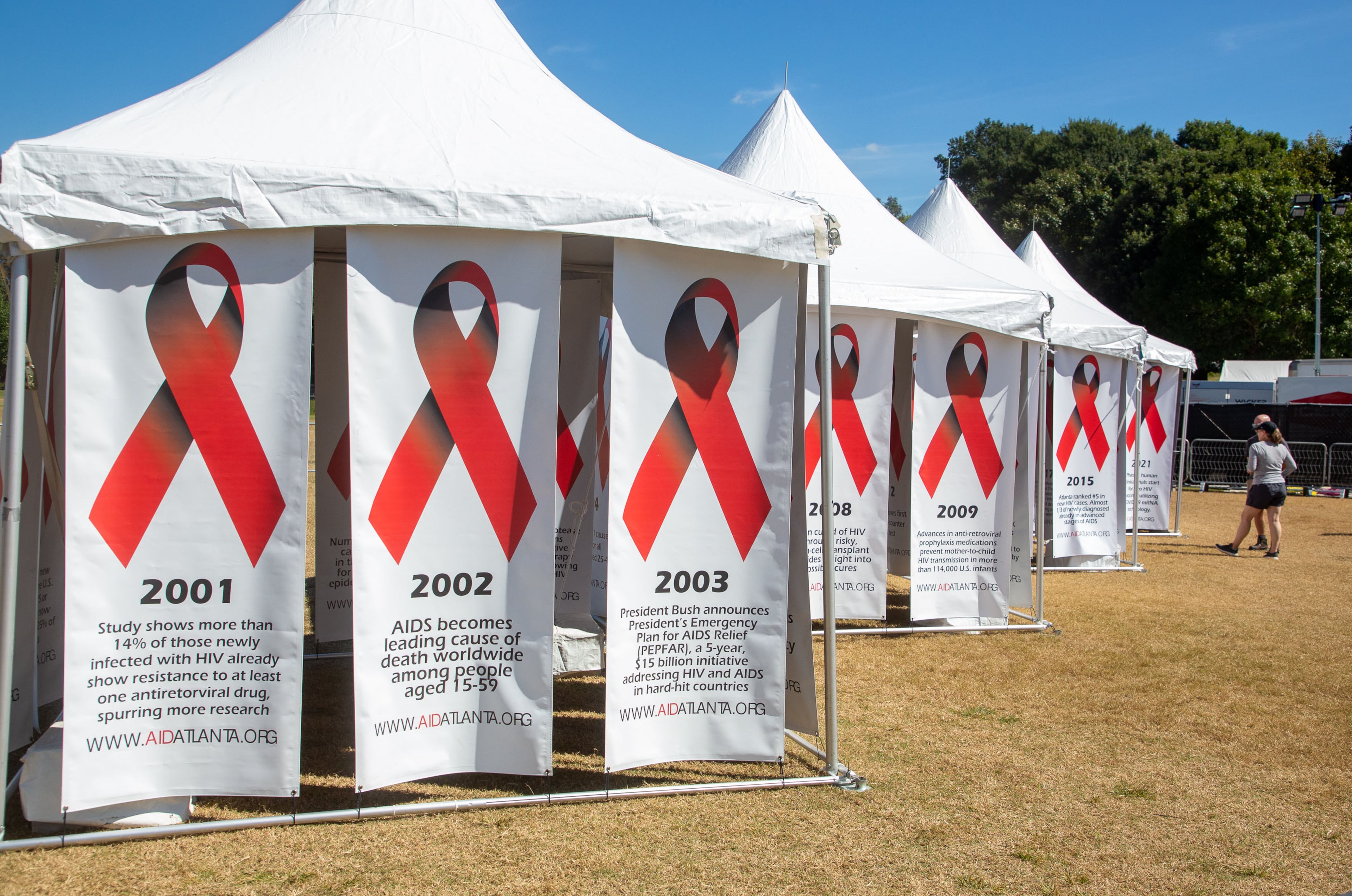 People look over the historical banners during the annual AIDS Walk Atlanta in Piedmont Park on Saturday, Sept. 25, 2021. (Steve Schaefer for the AJC)