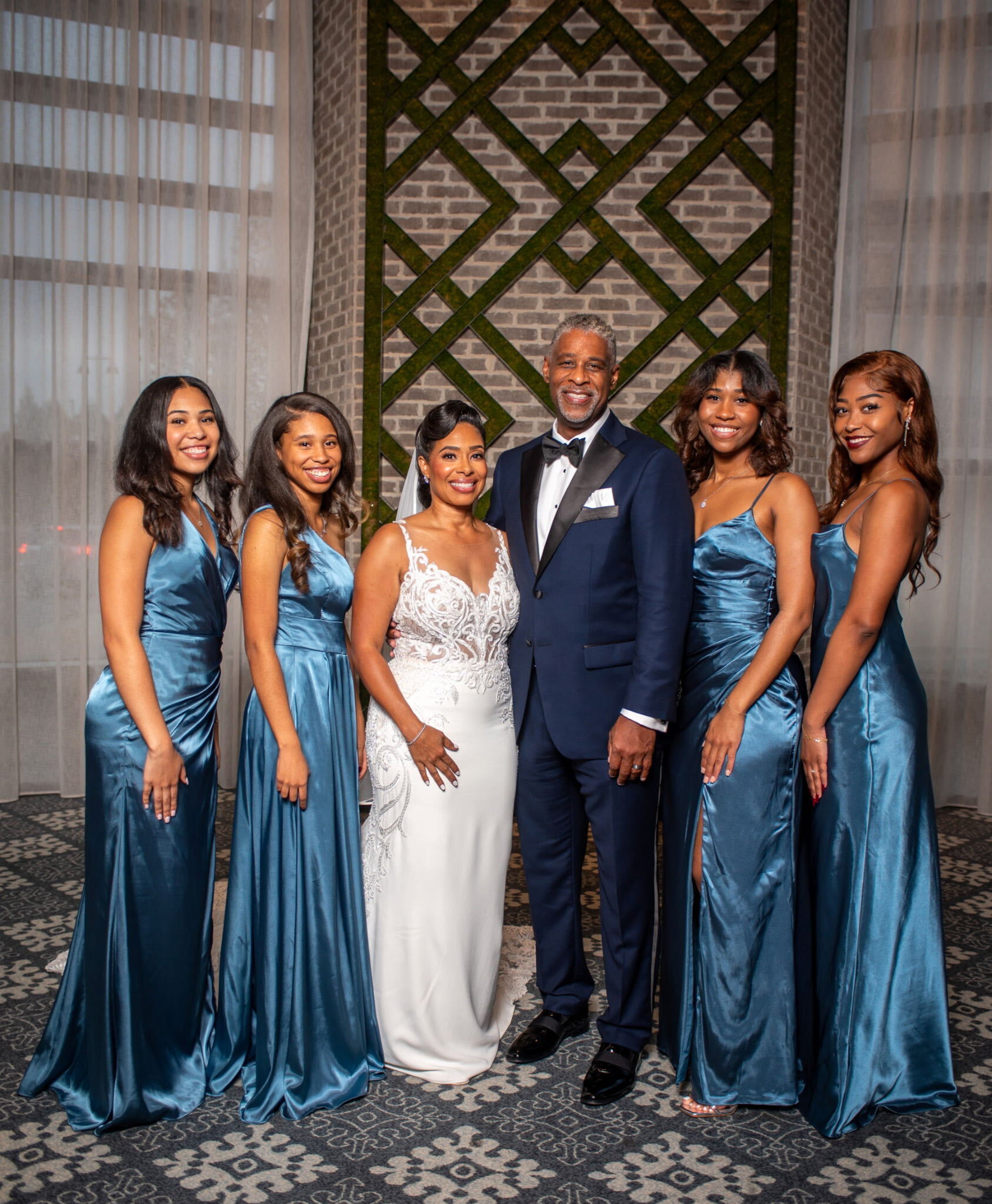 Spelman College alumna Dawn Fowler and Morehouse College alumnus Aundre Hayes at their wedding. The pair met at SpelHouse homecoming in 2019 and married in 2024. They stand with their daughters, who also attended Spelman College. (Courtesy of Dawn Fowler)