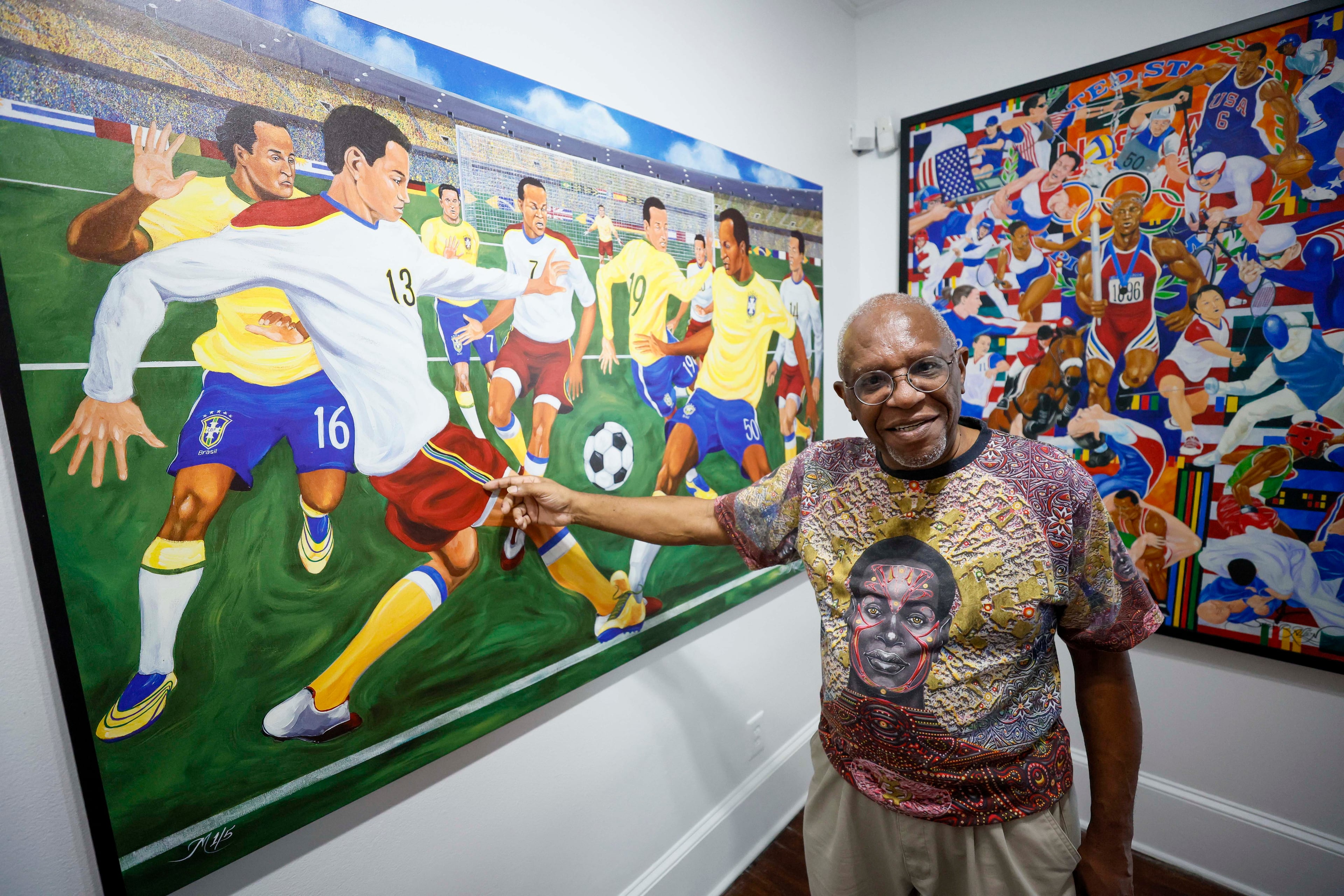Visual artist Steve Allen discusses the painting "O Jogo Bonito (The Beautiful Game)" during an exhibition at the Hammonds House Museum on Thursday, August 20, 2026. (Miguel Martinez/AJC)