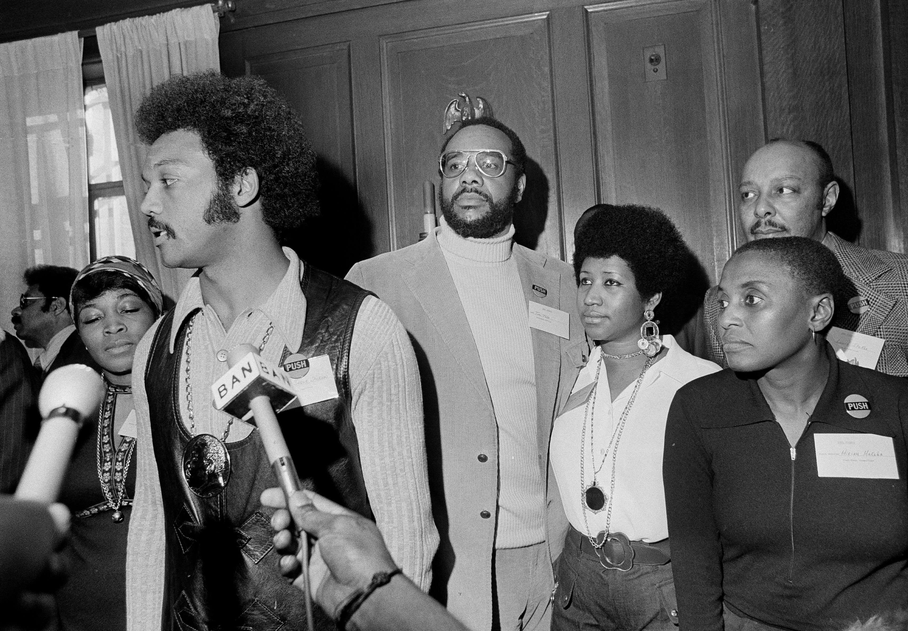 Jackson speaks to reporters at the Operation PUSH Soul Picnic at the 142nd Street Armory in New York, March 26, 1972. Also present were (left to right): Betty Shabazz, widow of Malcolm X; Tom Todd, vice president of PUSH; Aretha Franklin; singer Miriam Makeba and Rep. Louis Stokes, rear right. (Jim Wells/AP)
