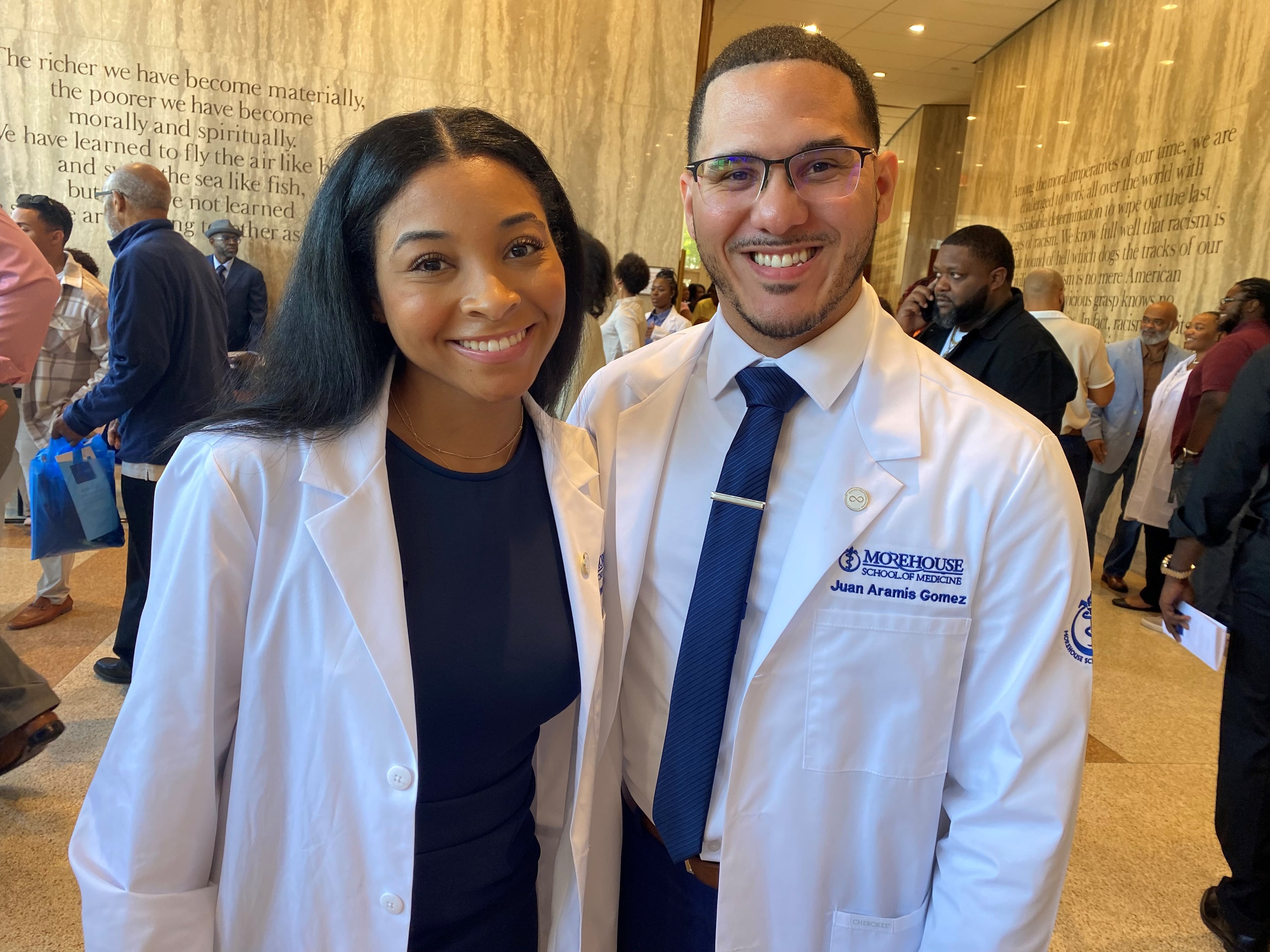Medical students Peyton Pritchett and Juan Gomez are shown just after their Morehouse School of Medicine "white coat ceremony" where students for the first time don white medical coats they will wear in clinical settings. The students' coats are shorter than the ones full doctors wear. The convocation was at Morehouse College's Martin Luther King, Jr. International Chapel on Friday, September 20, 2024. Photo by Ariel Hart.