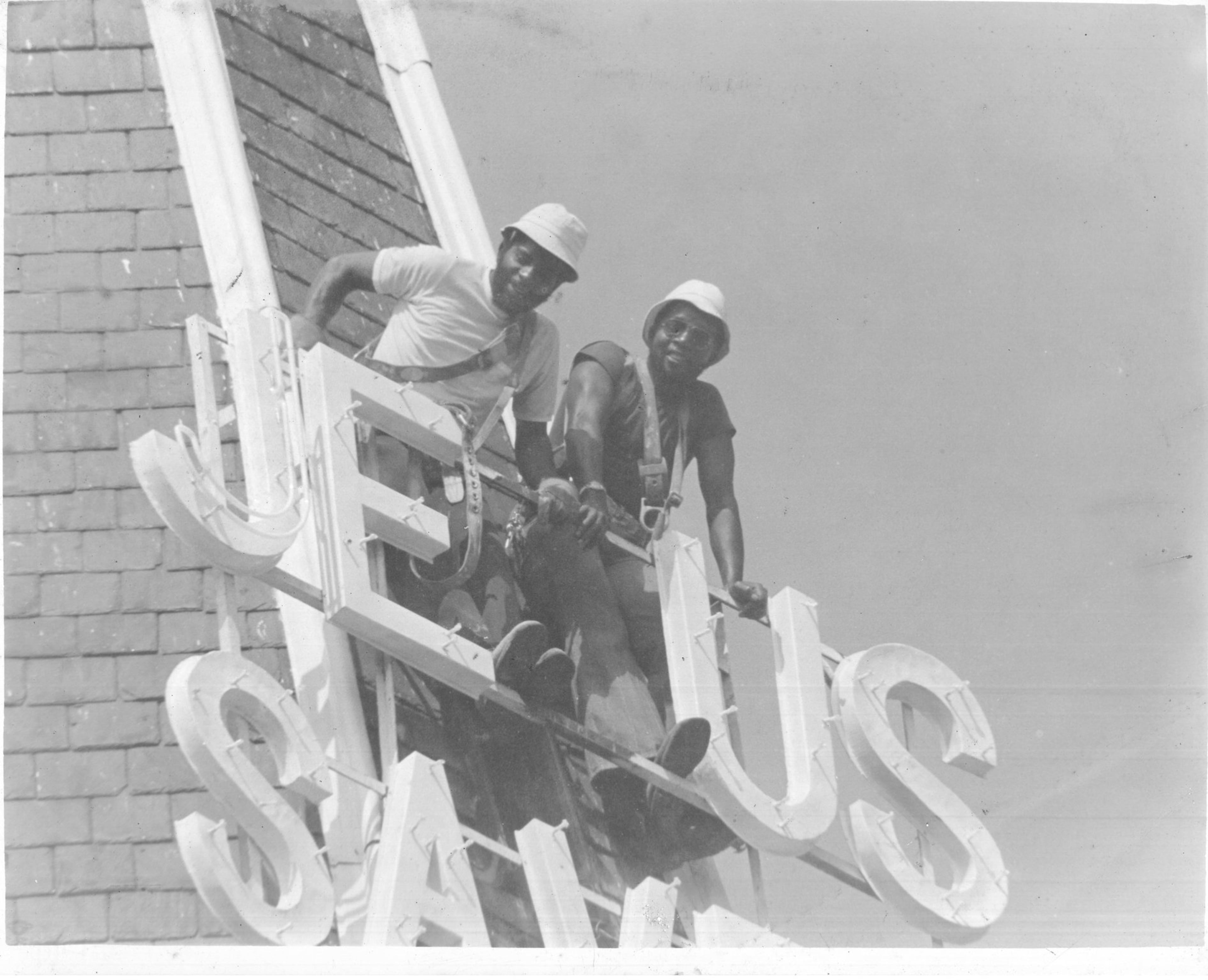 William Henry Stanford (dark shirt) and his brother Jerry Stanford, install a new Jesus Saves sign atop Big Bethel A.M.E. Church in 1979. (Courtesy of Jerrol Stanford 2019)