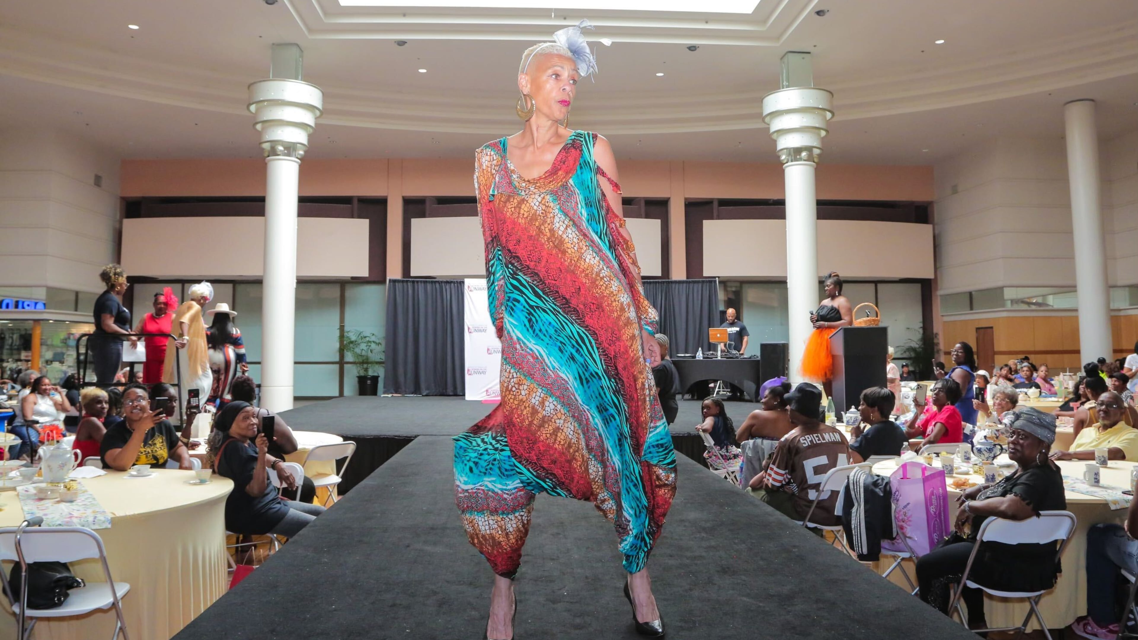 A model wearing a colorful dress struts on the catwalk at the 'Seniors on the Runway' event on May 4, 2024, at Greenbriar Mall in Atlanta. (Emily Heath)
