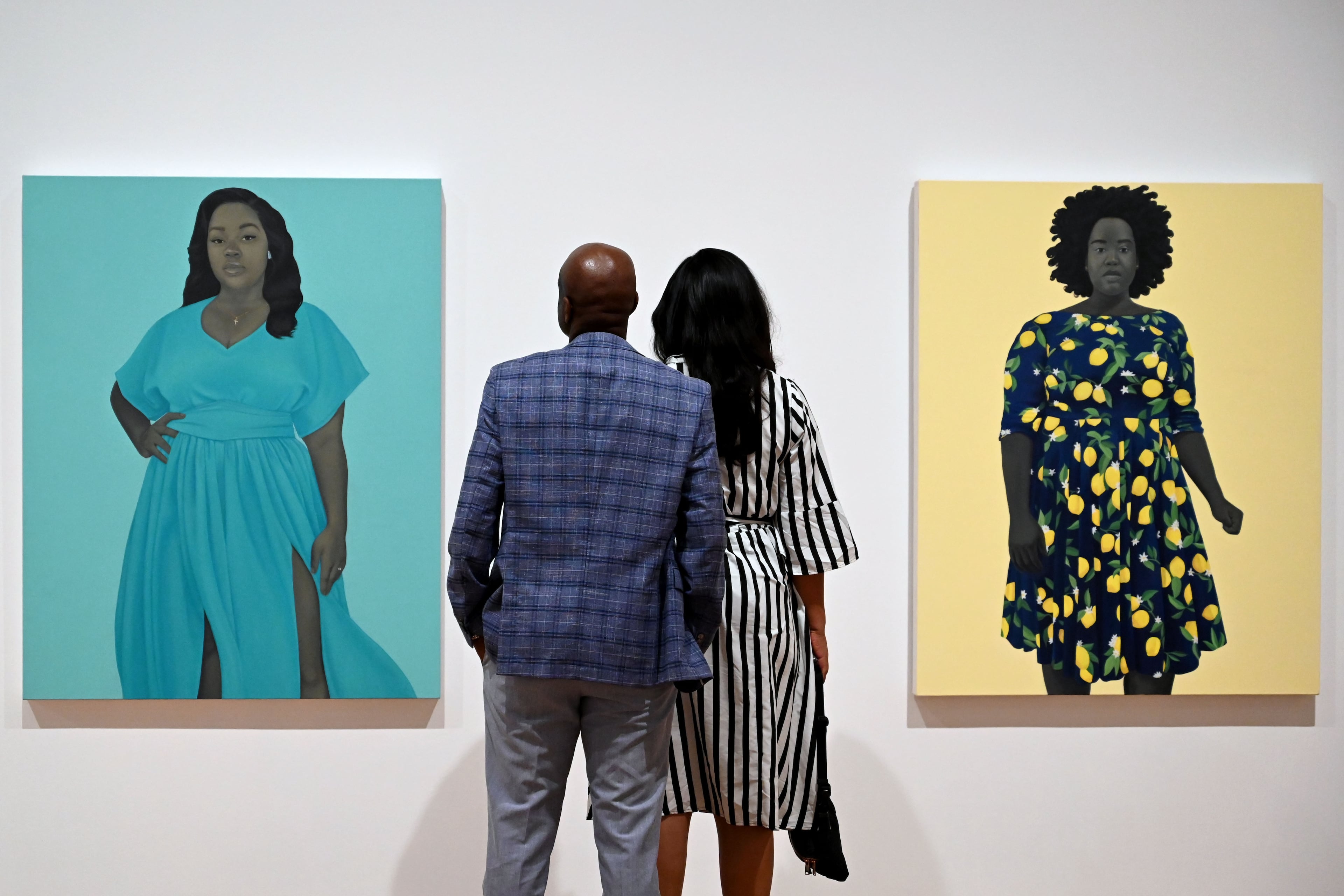 Visitors look at “Breonna Taylor” (left) and “She Always Believed the Good about Those She Loved” in the “American Sublime” exhibition at the High Museum of Art on Friday, May 15, 2026, in Atlanta. The latter painting features the model who stood in to pose for the portrait of the late Breonna Taylor. (Hyosub Shin/AJC)