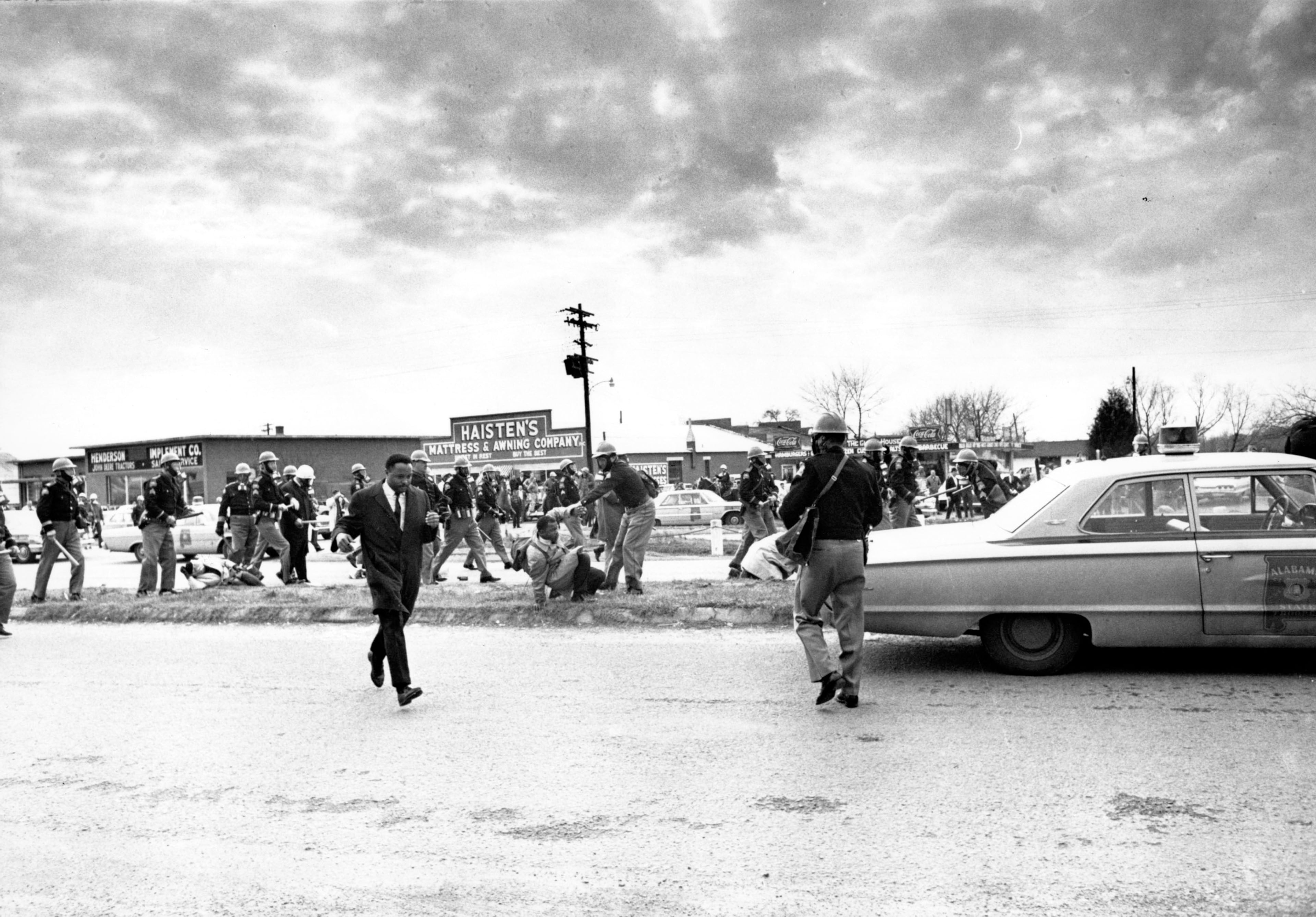 Hosea Williams (left), who led a march in Selma, Ala., leaves the scene as state troopers break up the demonstration on what is known as Bloody Sunday on March 7, 1965. Supporters of Black voting rights organized a march from Selma to Montgomery to protest the killing of a demonstrator by a state trooper and to improve voter registration for blacks, who are discouraged to register. (File)