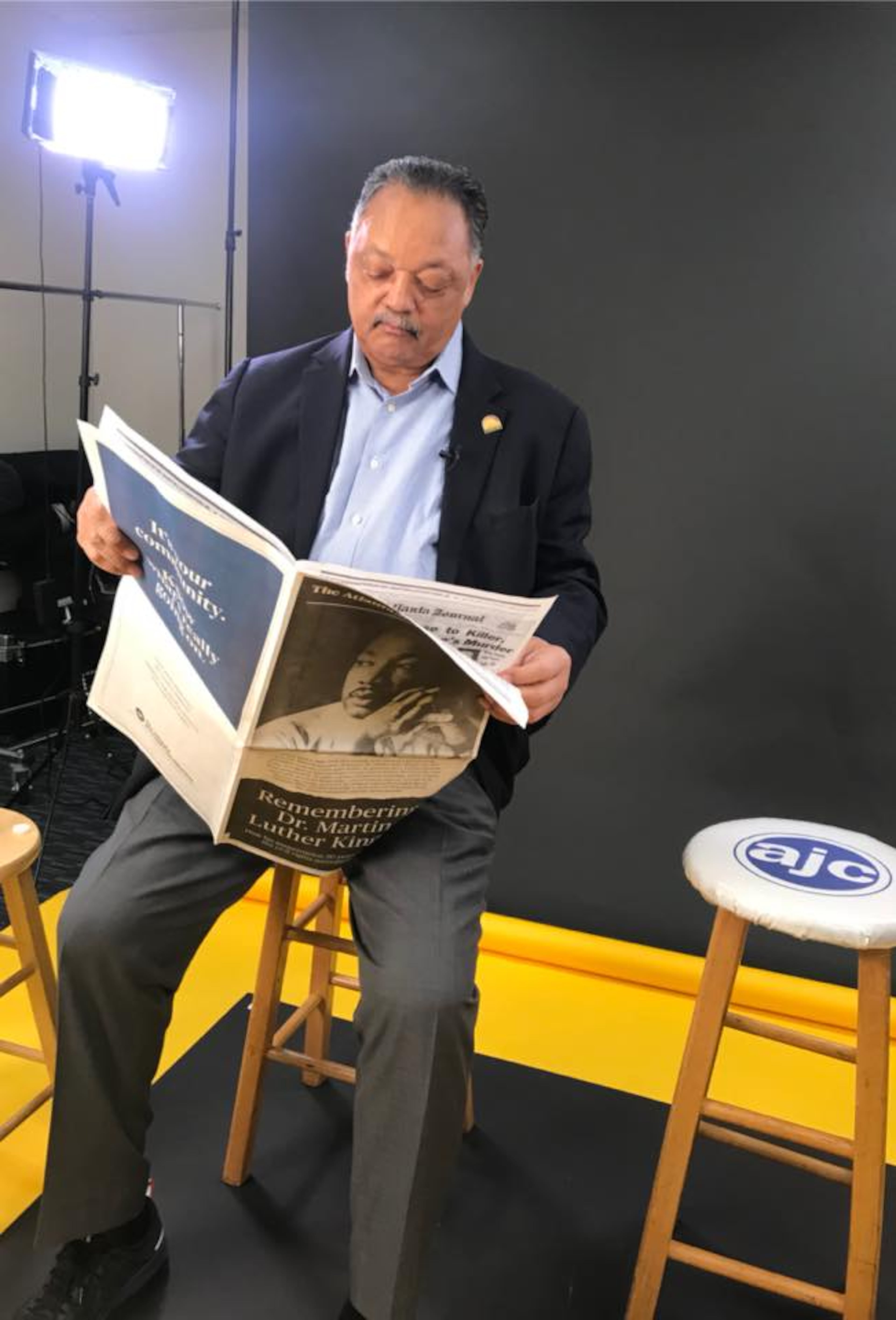 The Rev. Jesse Jackson looks through a special section on Martin Luther King Jr. during a 2018 visit to the newspaper's offices. (Staff/AJC)