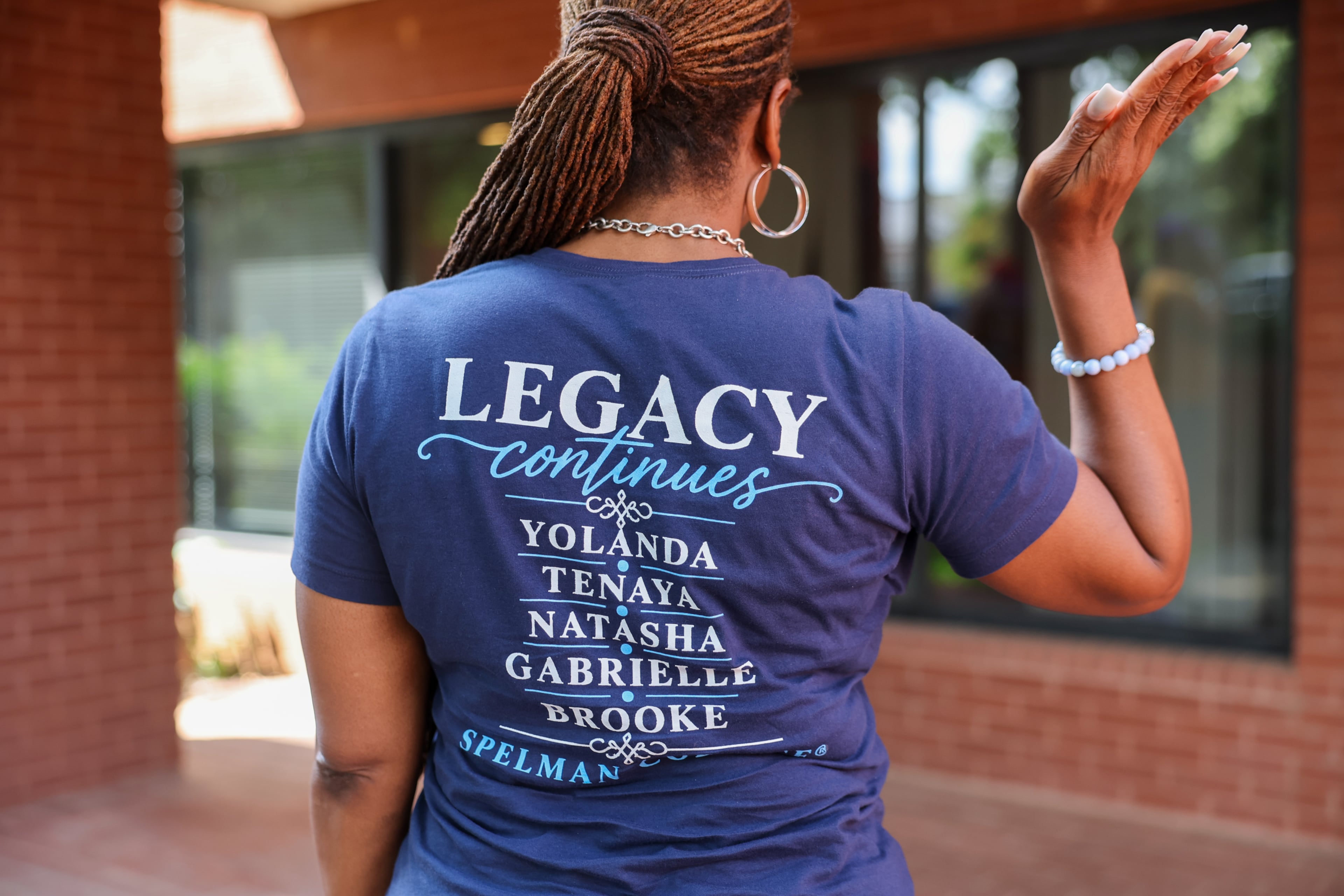 Alumna Yolanda Watson Spiva, mother of first-year honors student Brooke Spiva, showcases a shirt that honors family alumnae at Spelman College in Atlanta on Aug. 11, 2026. (Arvin Temkar/AJC)