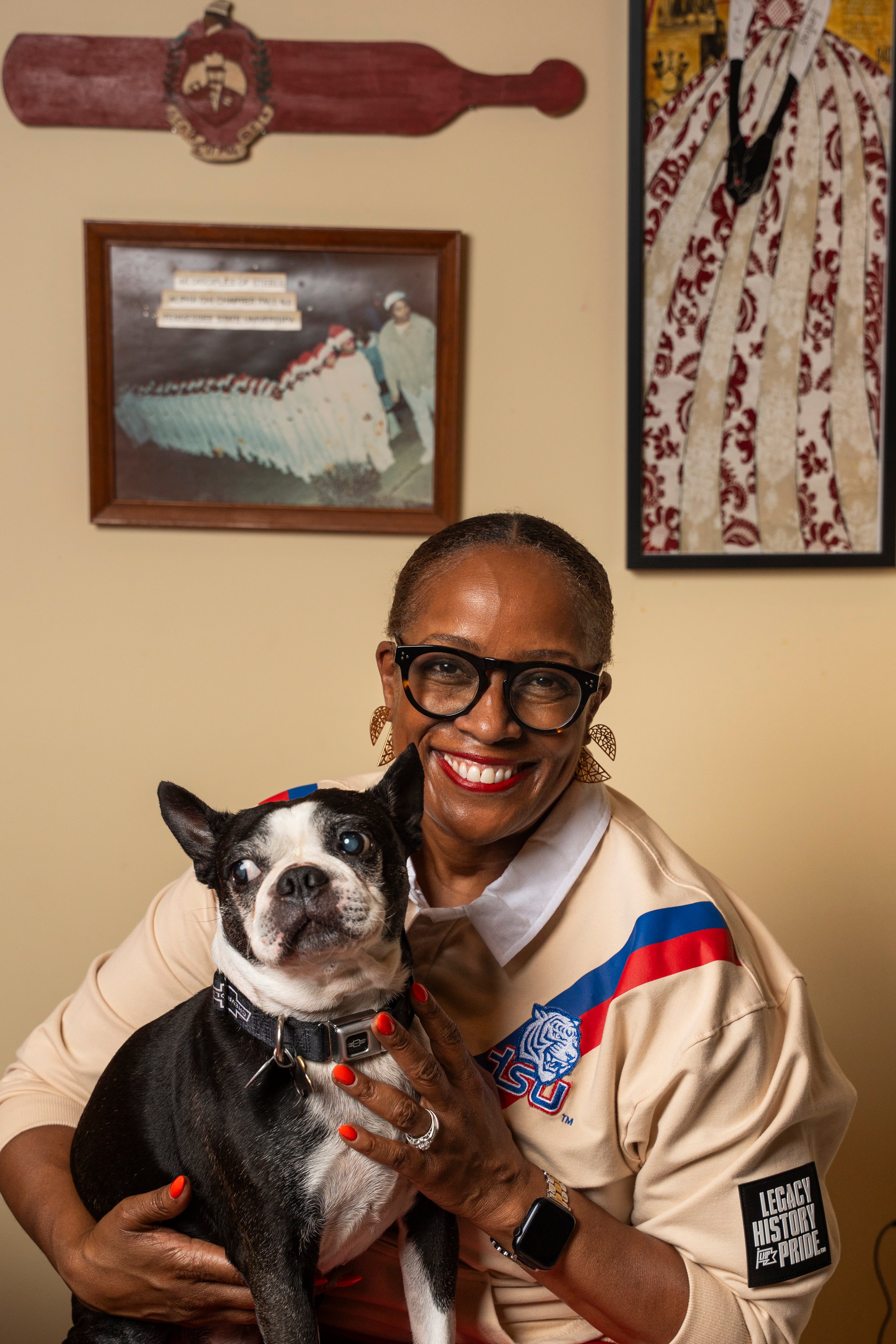 Latise Egeston holds her dog, Chevy, in the memorabilia room of her Stone Mountain home on Friday, Sept. 18, 2026. Egeston pledged the Alpha Chi Chapter of Delta Sigma Theta Sorority, Inc. at Tennessee State University, an HBCU in Nashville. (Olivia Bowdoin for the AJC)