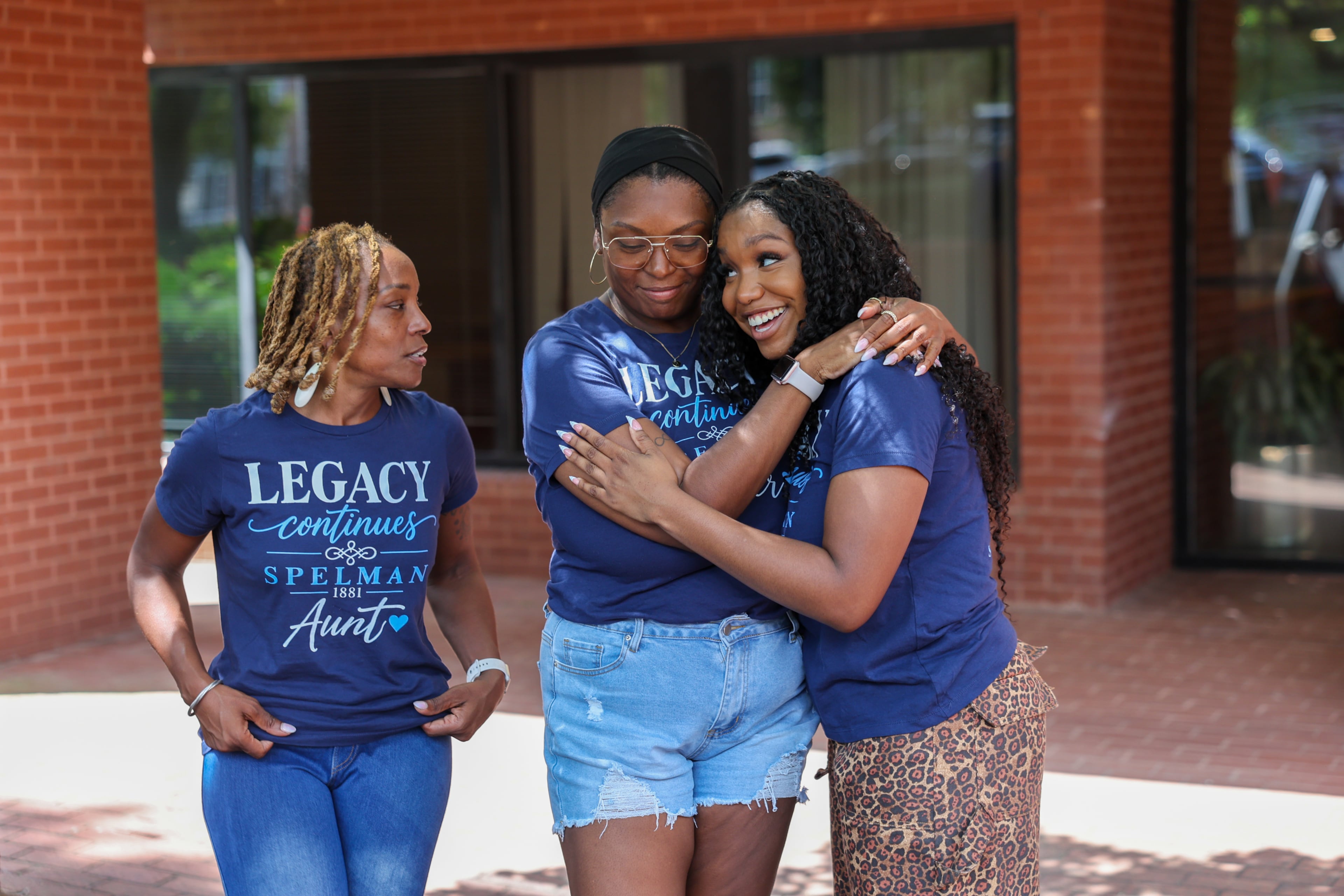 First-year honors student Brooke Spiva (right) hugs her sister Gabbie Moore as their mother Yolanda Watson Spiva looks on at Spelman College in Atlanta on Aug. 11, 2026. (Arvin Temkar/AJC)