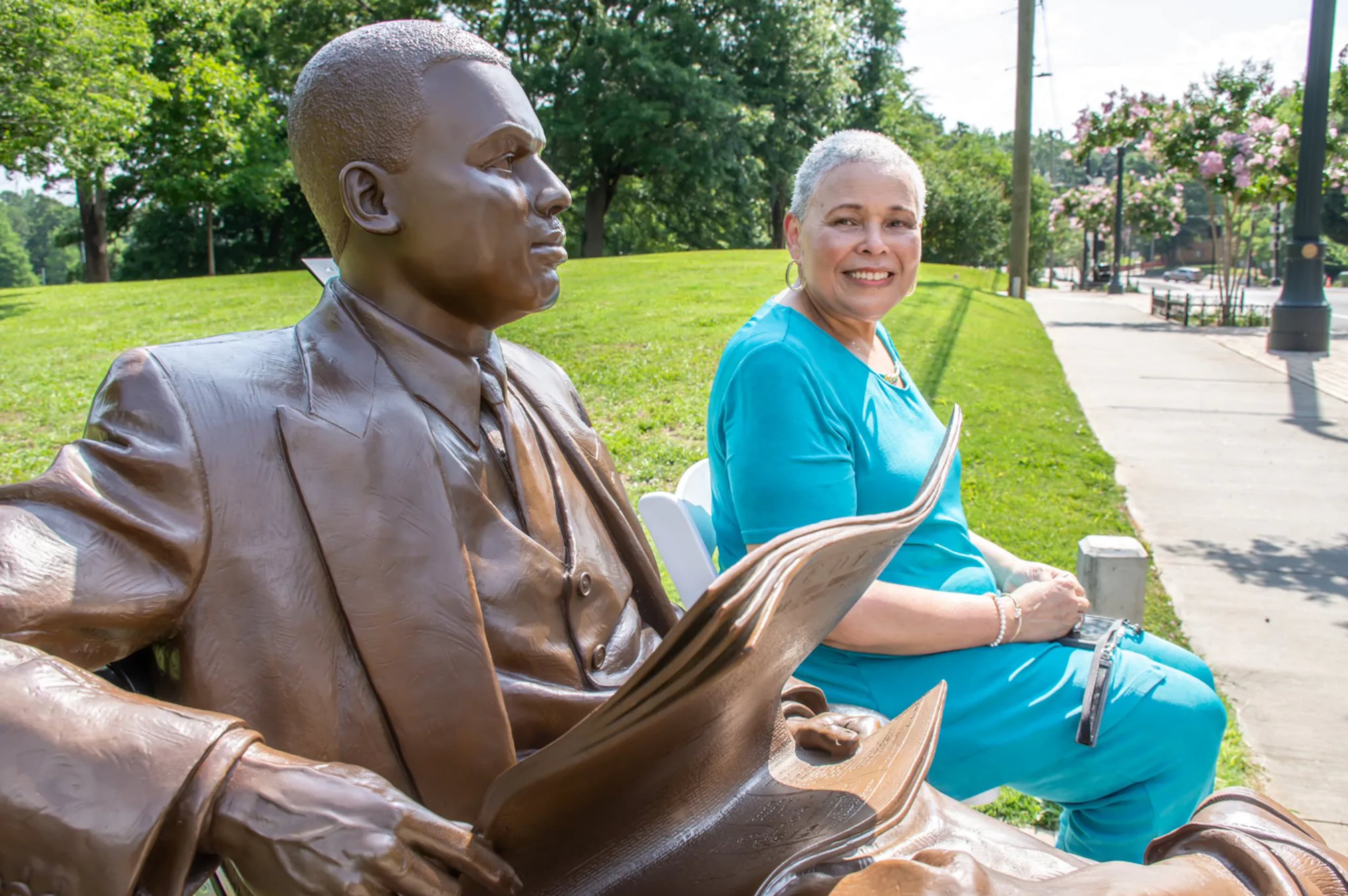 Alexis Scott joined The Atlanta Constitution in 1974. She sits beside a sculpture of her grandfather, Black businessman and newspaper publisher William Alexander Scott II, founder of the Atlanta Daily World. (Courtesy of city of Atlanta)