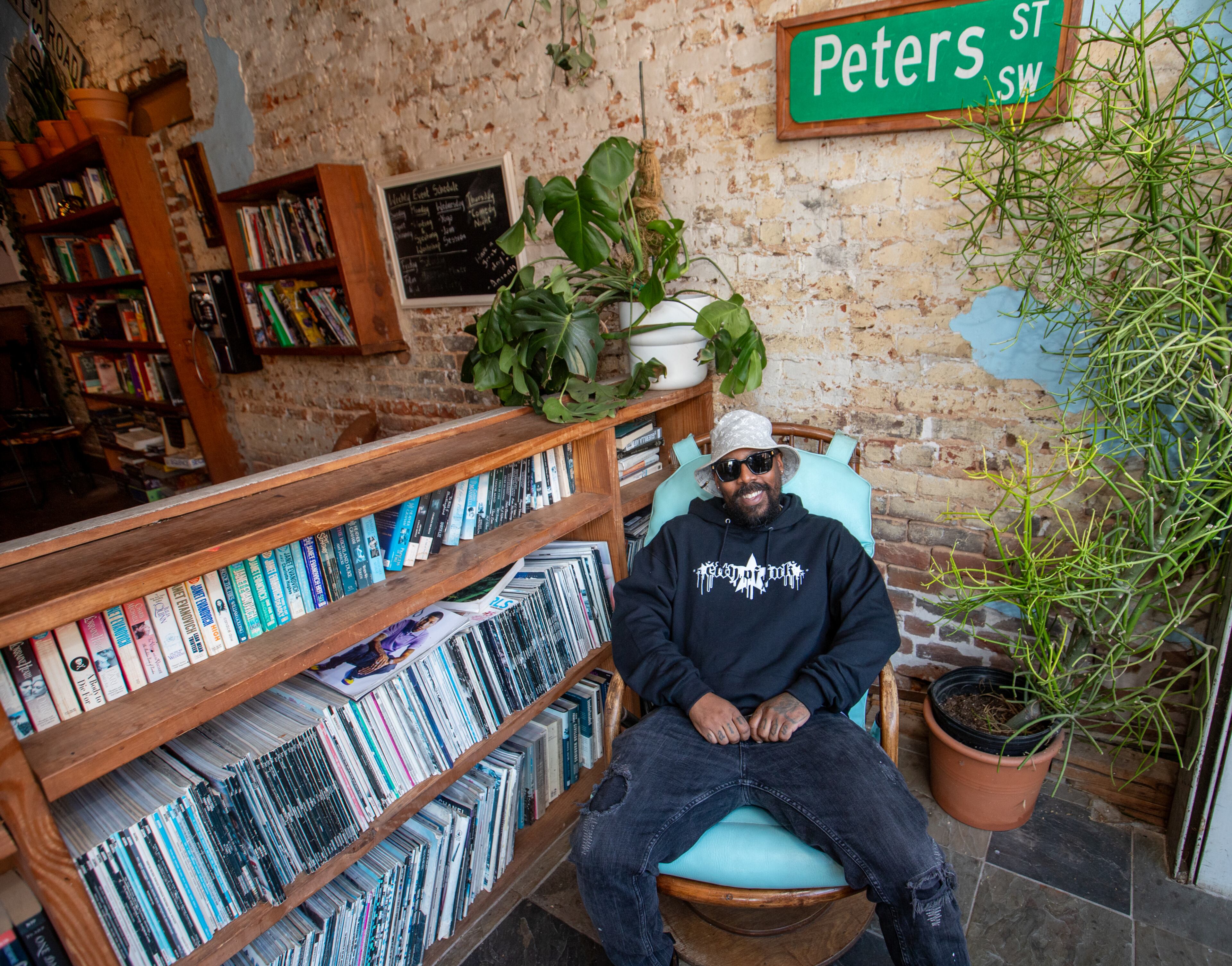 Miya Bailey relaxes at Peters Street Station, a community center and coffee shop with a back room art gallery on Walker Street. Bailey, who also owns City of Ink on the same block, is the entrepreneur, tattoo artist and property owner who continues to be a creative inspiration for the community. (Jenni Girtman for the AJC 2024)