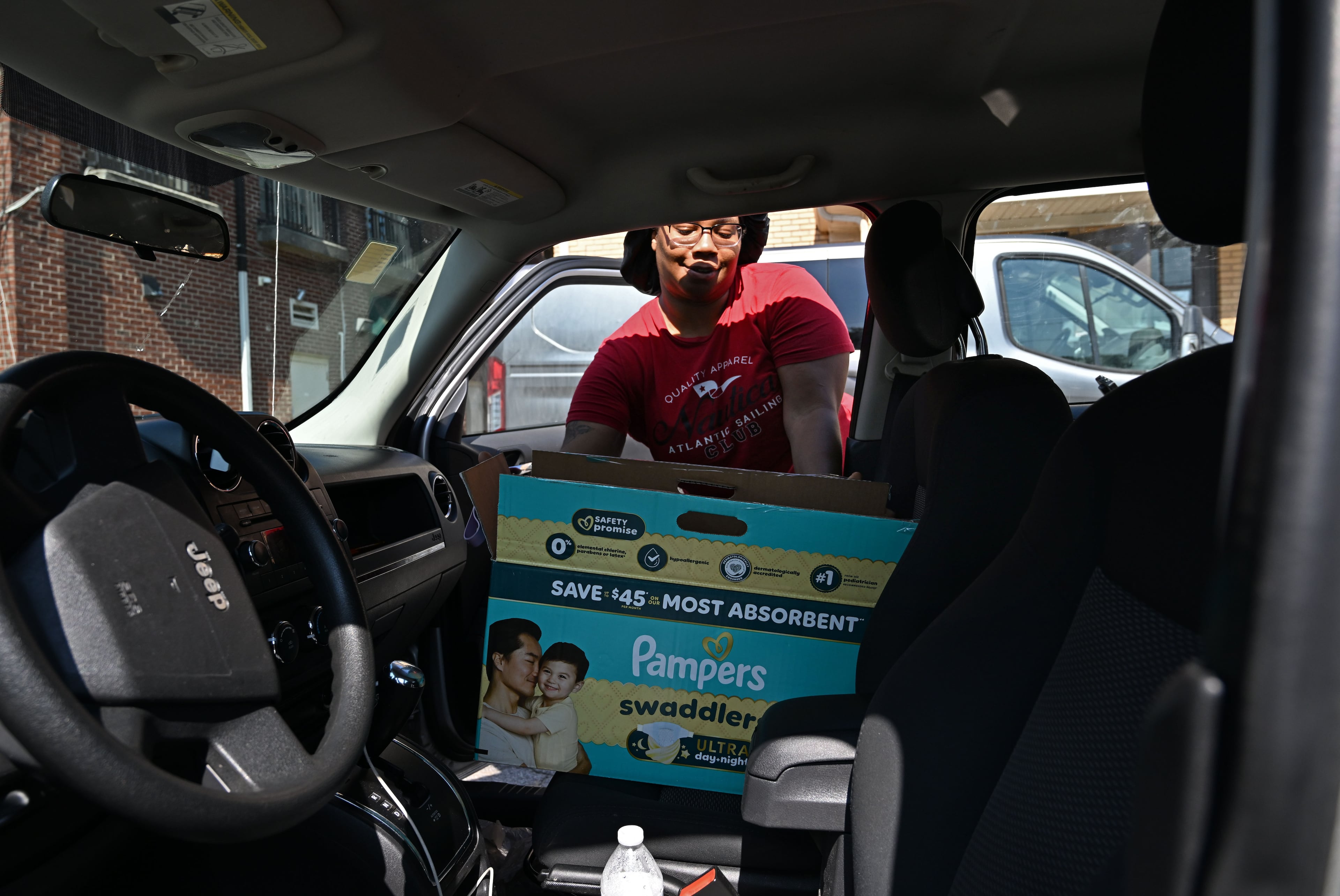 Antoinette Mason loads a box of baby essentials into her car outside the Tender Foundation's Diaper Bank on Saturday, July 11, 2026, in East Point. (Hyosub Shin/AJC)