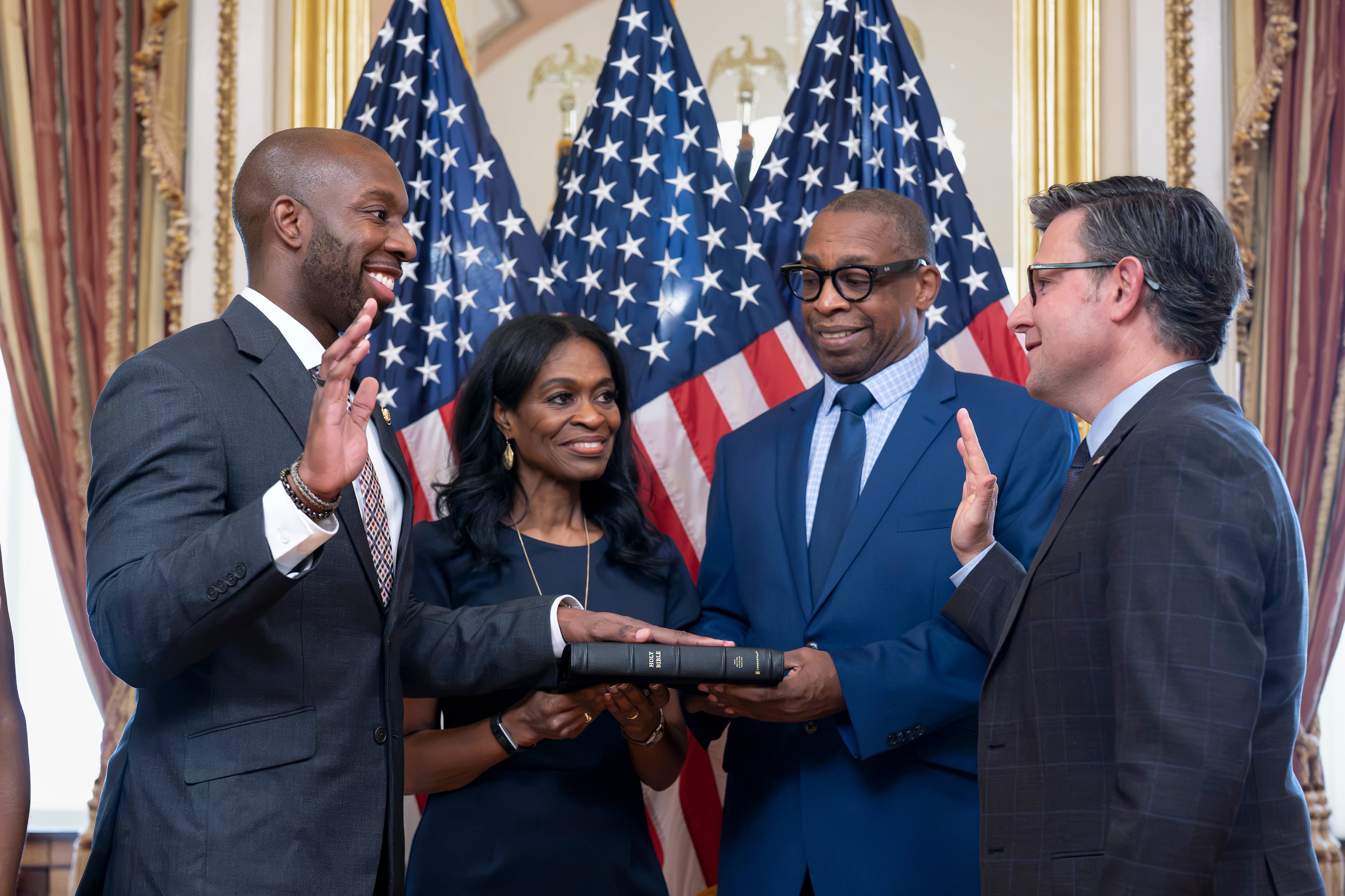 From left, new Rep. Everton Blair Jr., D-Ga. — joined by his mother, Fiona Blair, and father, Everton Blair Sr. — gets sworn in by Speaker of the House Mike Johnson, R-La., in September after Blair won a special election to replace the late Georgia Rep. David Scott. (J. Scott Applewhite/AP)