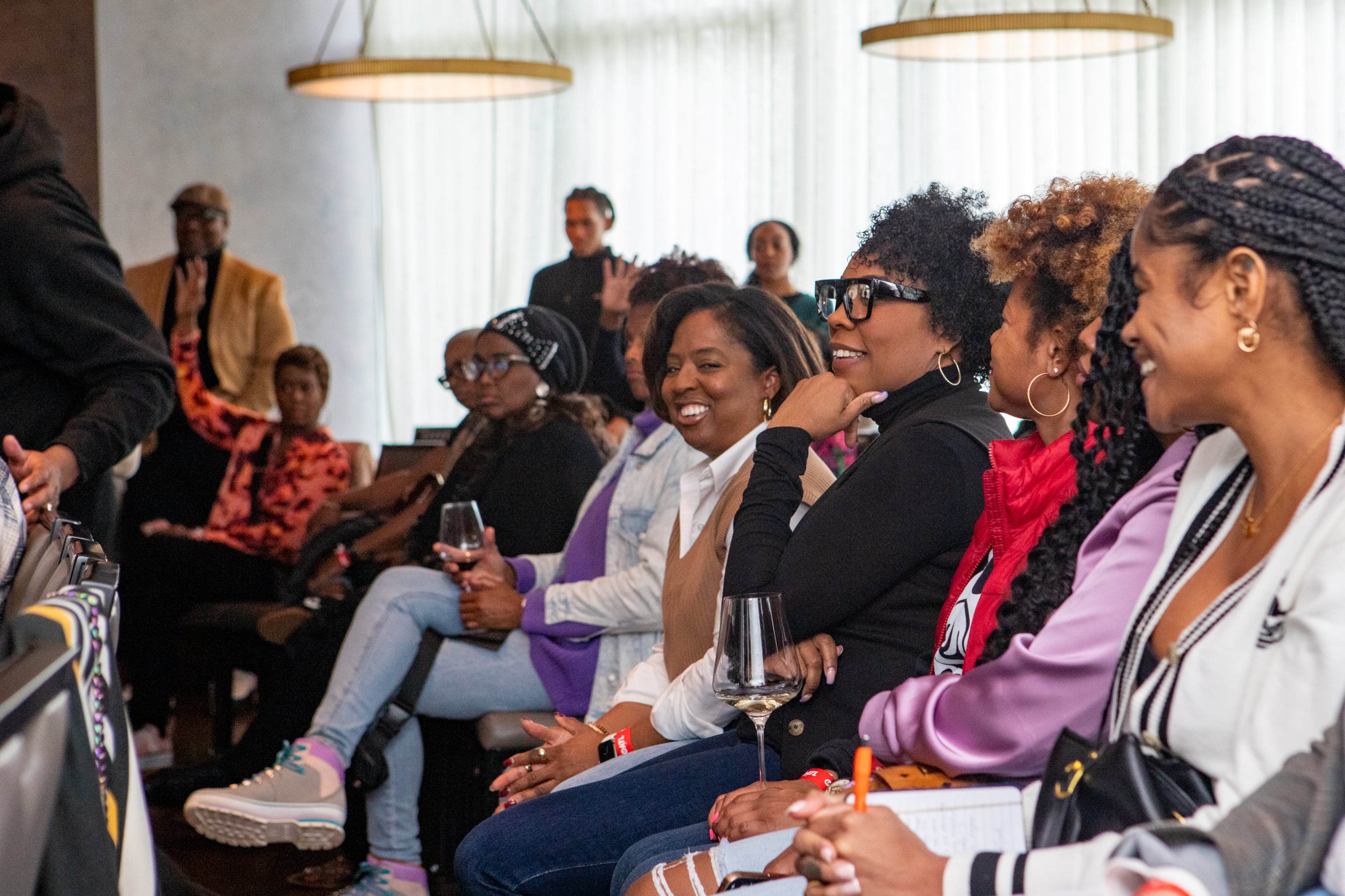 April Green (center with glasses), an event consultant and small business owner, attends UATL’s Culture Connect panel discussion on the future of DEI and Black culture at Thompson Atlanta hotel in Buckhead on Feb 22, 2024. (Jenni Girtman for the AJC)