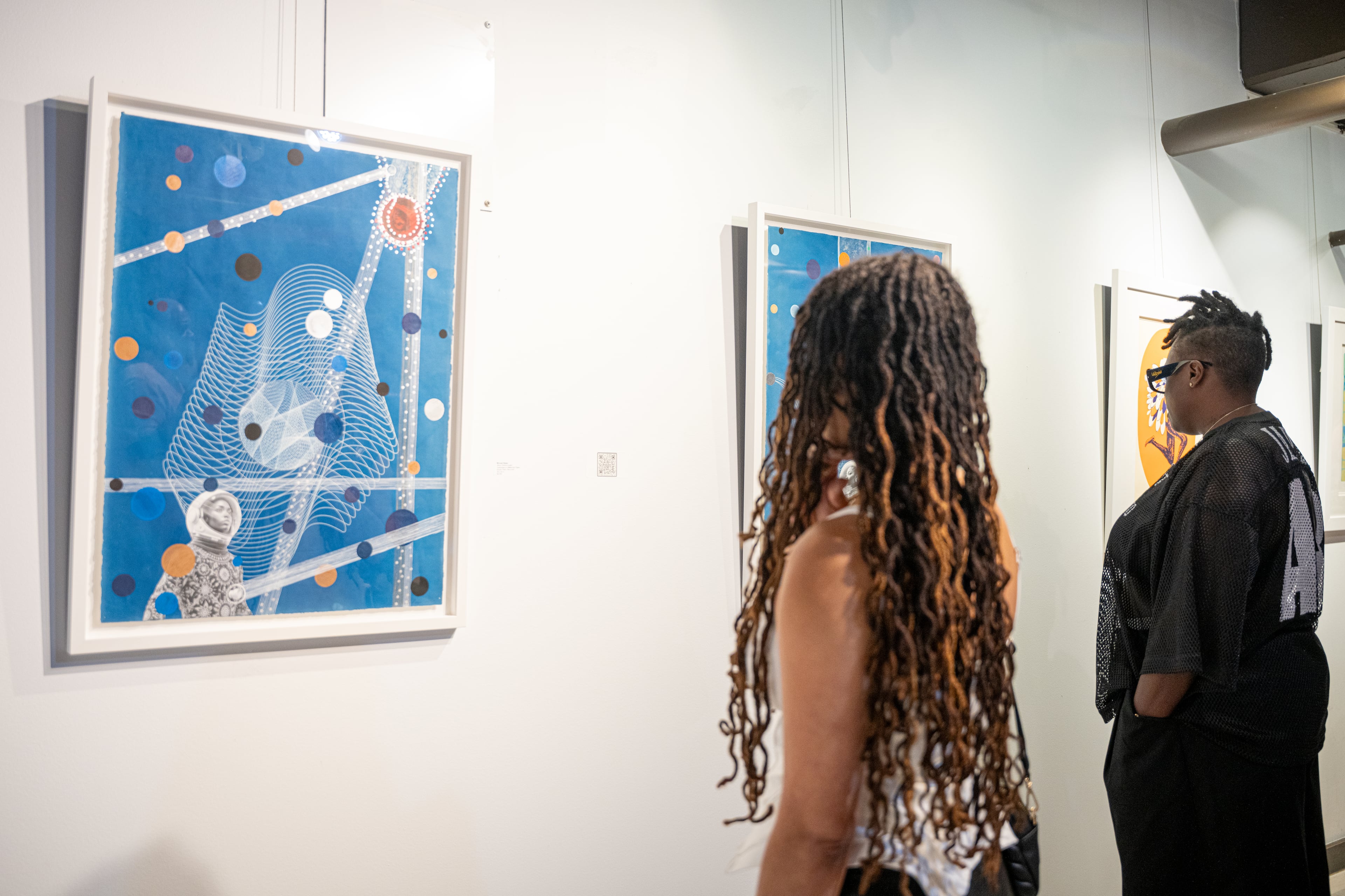 A visitor looks at "Wave Particle Duality" by Michael Reese, part of "Dear Black People...A Love Letter" at ZuCot Gallery. (Courtesy of John Stephens)