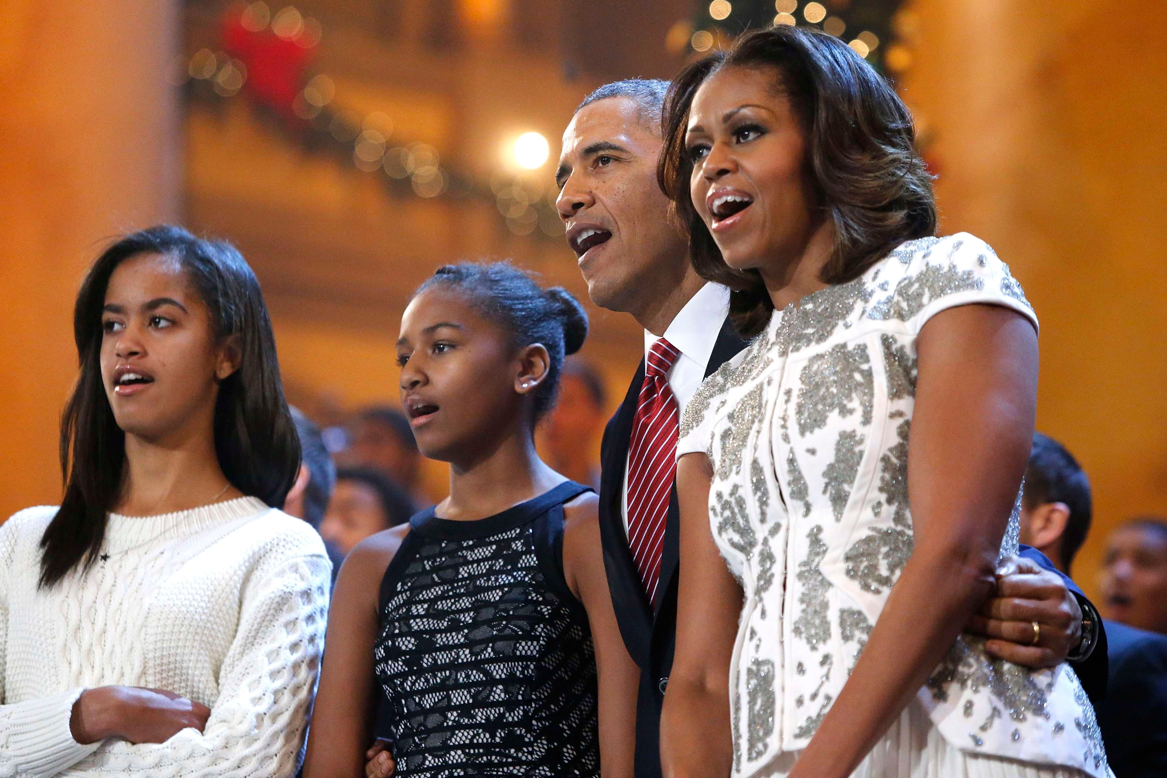 U.S. President Barack Obama (2nd R), his wife Michelle (R) and their daughters Malia (L) and Sasha (2nd L) join performers onstage to sing Christmas carols during a taping of the Christmas in Washington television benefit program at the National Building Museum in Washington, Dec. 15, 2013. The 32nd annual Christmas in Washington show, benefiting the Children's National Health System, featured performers Hugh Jackman, Backstreet Boys, Sheryl Crow, Anna Kendrick, Janelle Monae and Pat Monahan. (Courtesy of Jonathan Ernst)