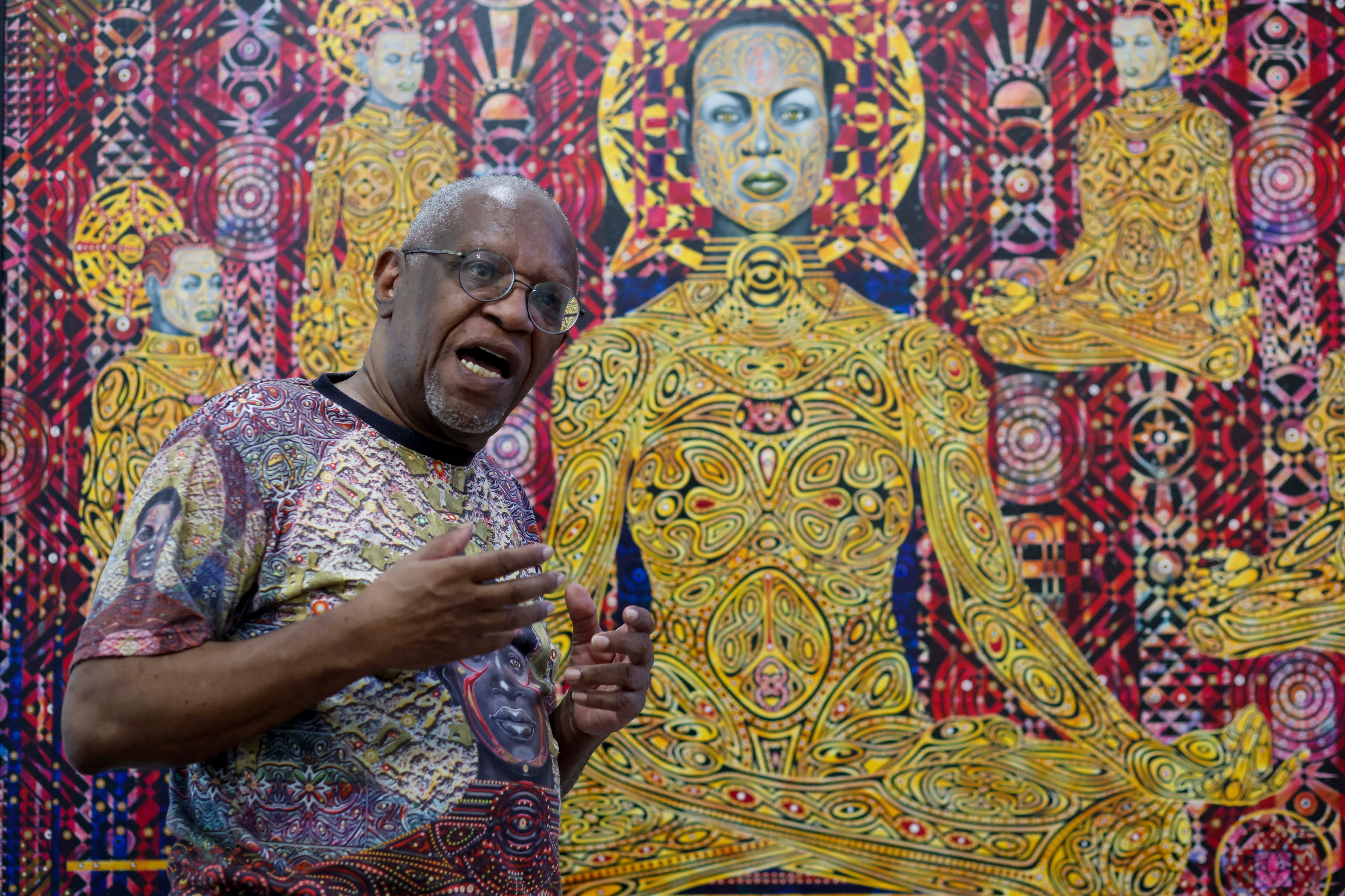 Visual artist Steve Allen is seen explaining the elements and inspiration behind the paintings in his exhibit at the Hammonds House Museum on Thursday, August 20, 2026. (Miguel Martinez/AJC)