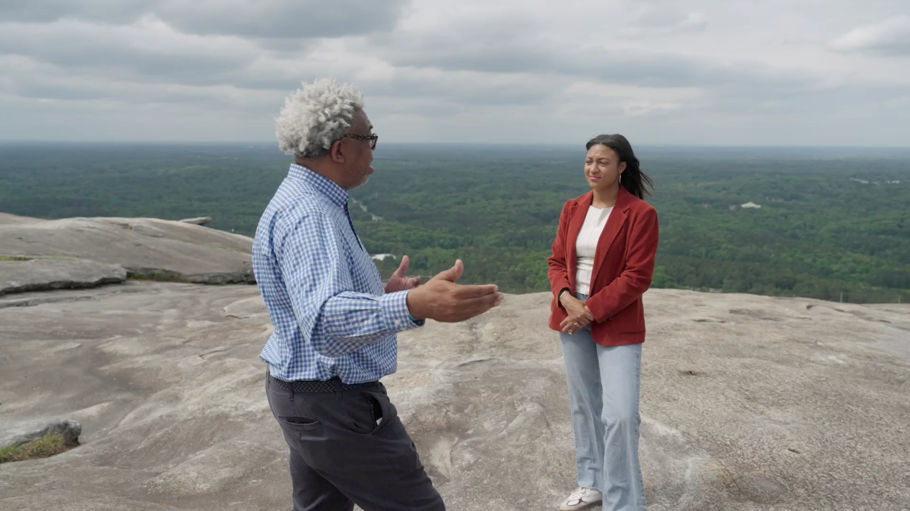 Senior reporter Ernie Suggs and AJC producer Koralie Barrau discuss the Confederate monument while standing on Stone Mountain. (Stephen Mucci/AJC)