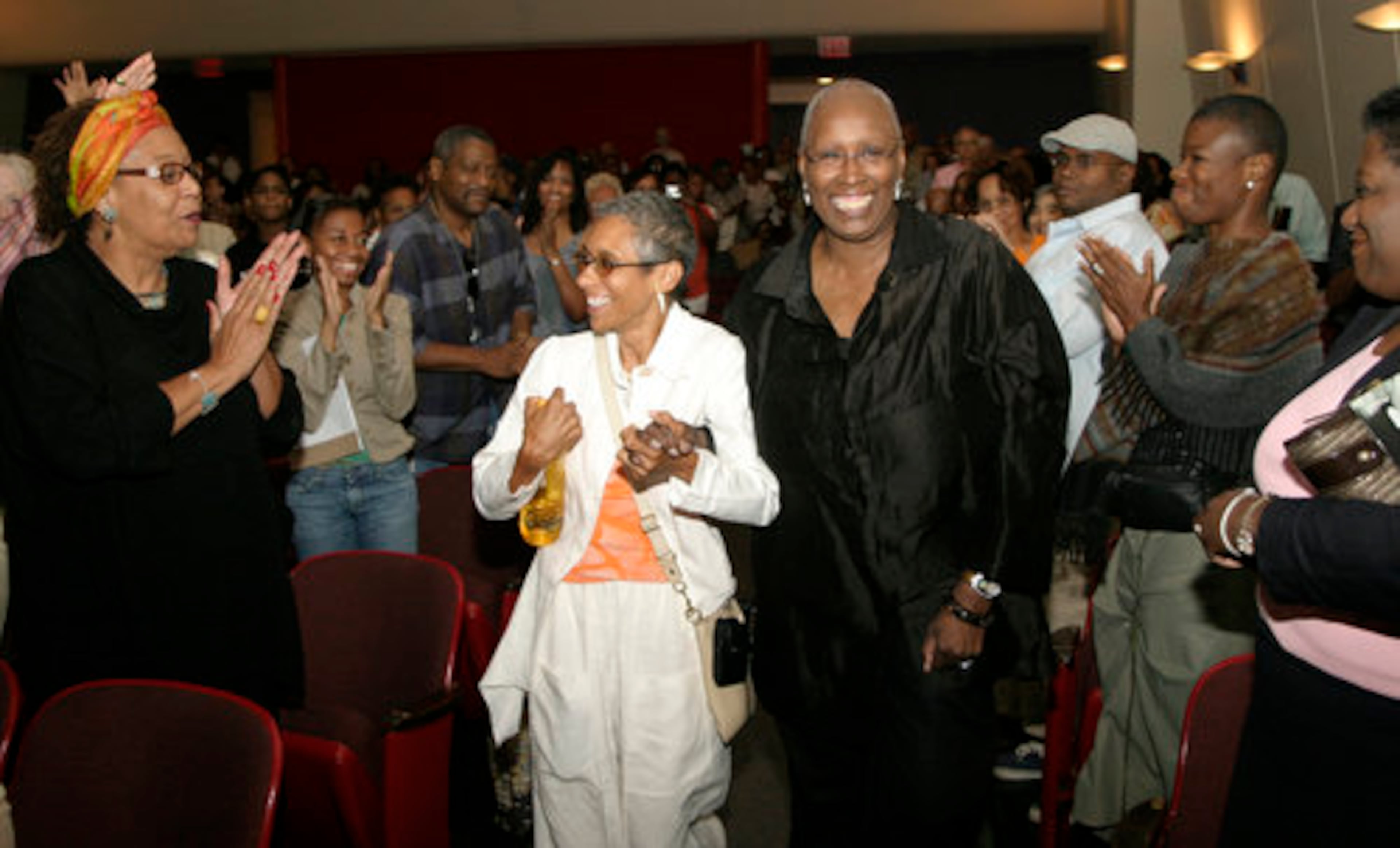 The standing-room-only audience at the Rich Theatre welcomes NBAF executive director Stephanie Hughley (center) and Judith Jamison (right), artistic director of the Alvin Ailey American Dance Theater, as they are escorted to the stage for a conversation with author/playwright Pearl Cleage. The event was part of the Creatively Speaking series. (Sean Drakes for the AJC 2008)