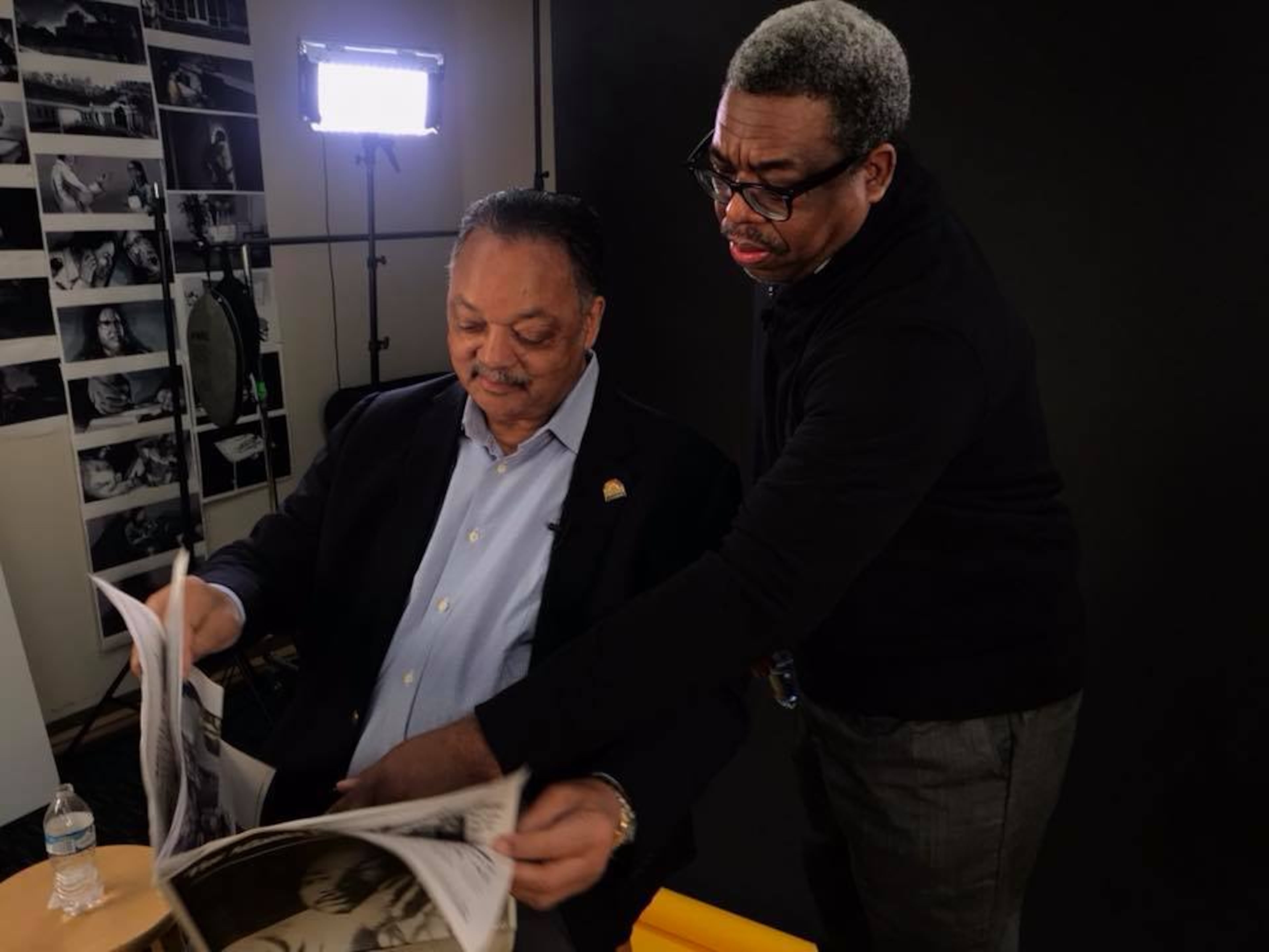 Reporter Ernie Suggs (right) shows the Rev. Jess Jackson the AJC's special section marking the 50th anniversary of Martin Luther King Jr.'s assassination. (Staff/AJC)