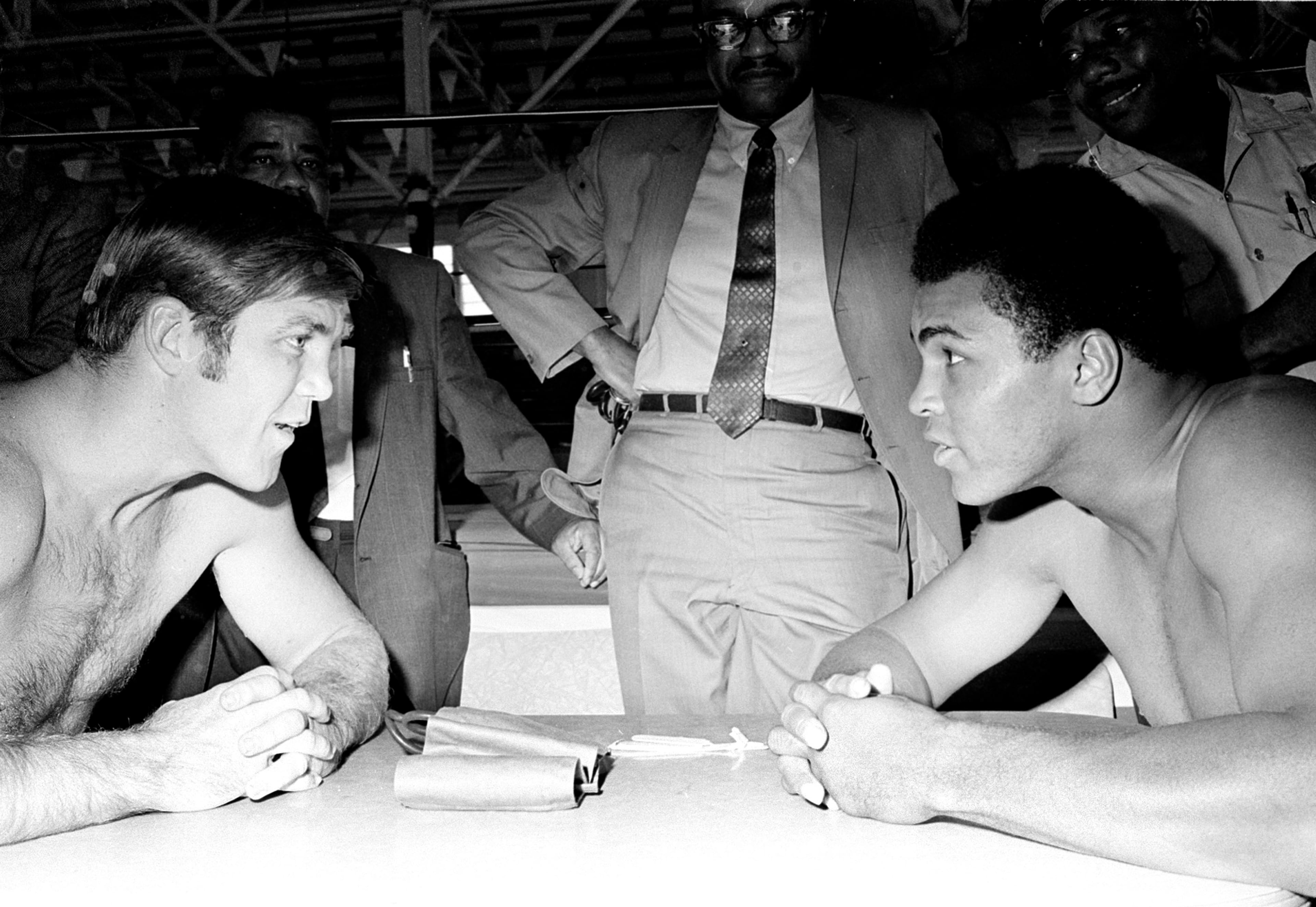 Heavyweight boxers Jerry Quarry (left) and Muhammad Ali face each other at a ringside table following their physical examinations Oct. 21, 1970, in Atlanta. The two were poised to meet in a 15-round, non-title fight Oct. 26. Quarry was the No. 1 heavyweight contender at the time.
