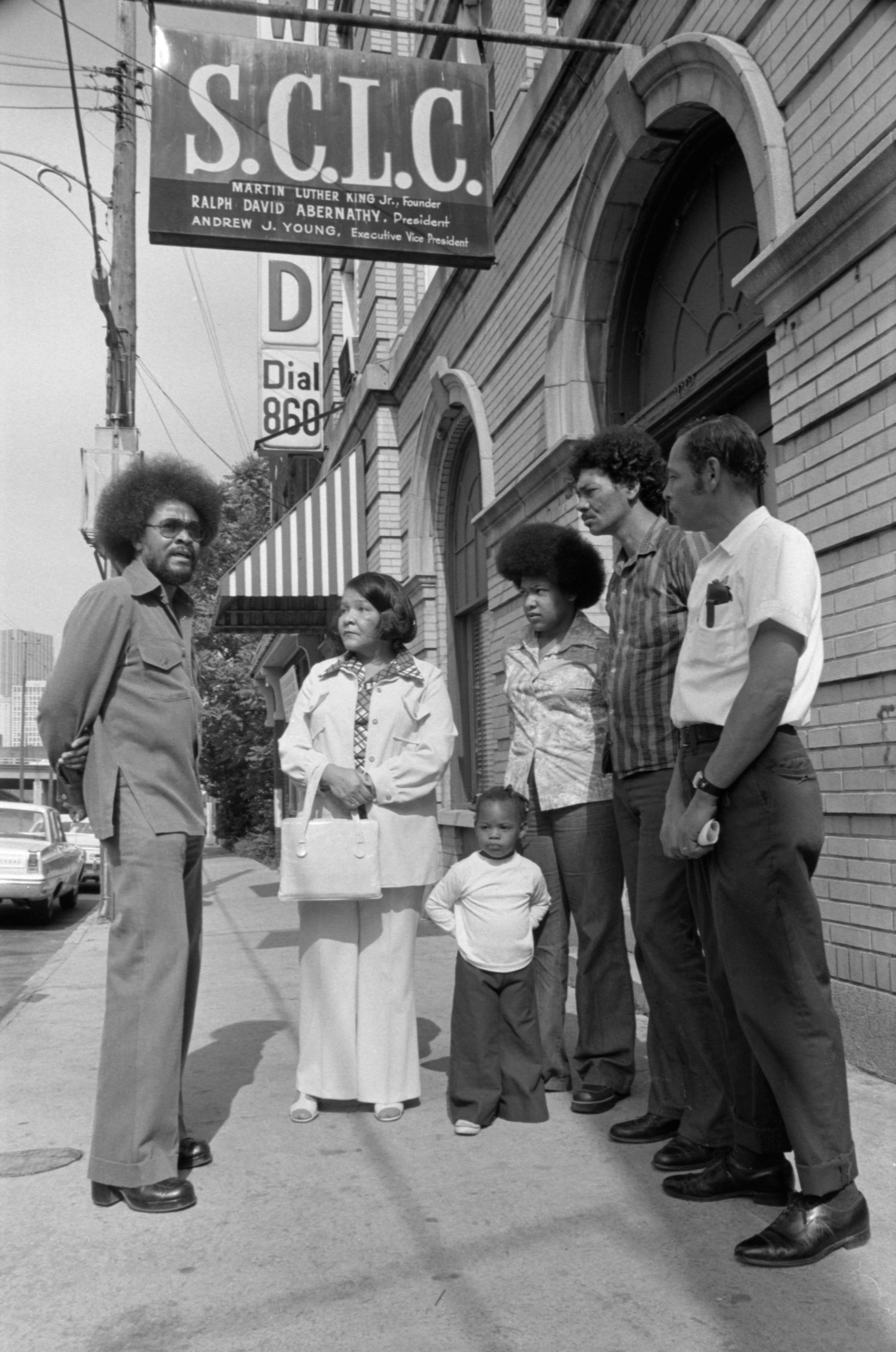 Tyrone Brooks (far left), then a Southern Christian Leadership Conference staffer, talks with an unidentified family outside the SCLC office on Auburn Avenue in this undated photo. The SCLC has roots dating back to the late '50s, when a group of civil rights leaders founded the organization to promote nonviolent action against segregation. The Rev. Martin Luther King Jr. was its first president. (Boyd Lewis/Courtesy of Kenan Research Center at the Atlanta History Center)