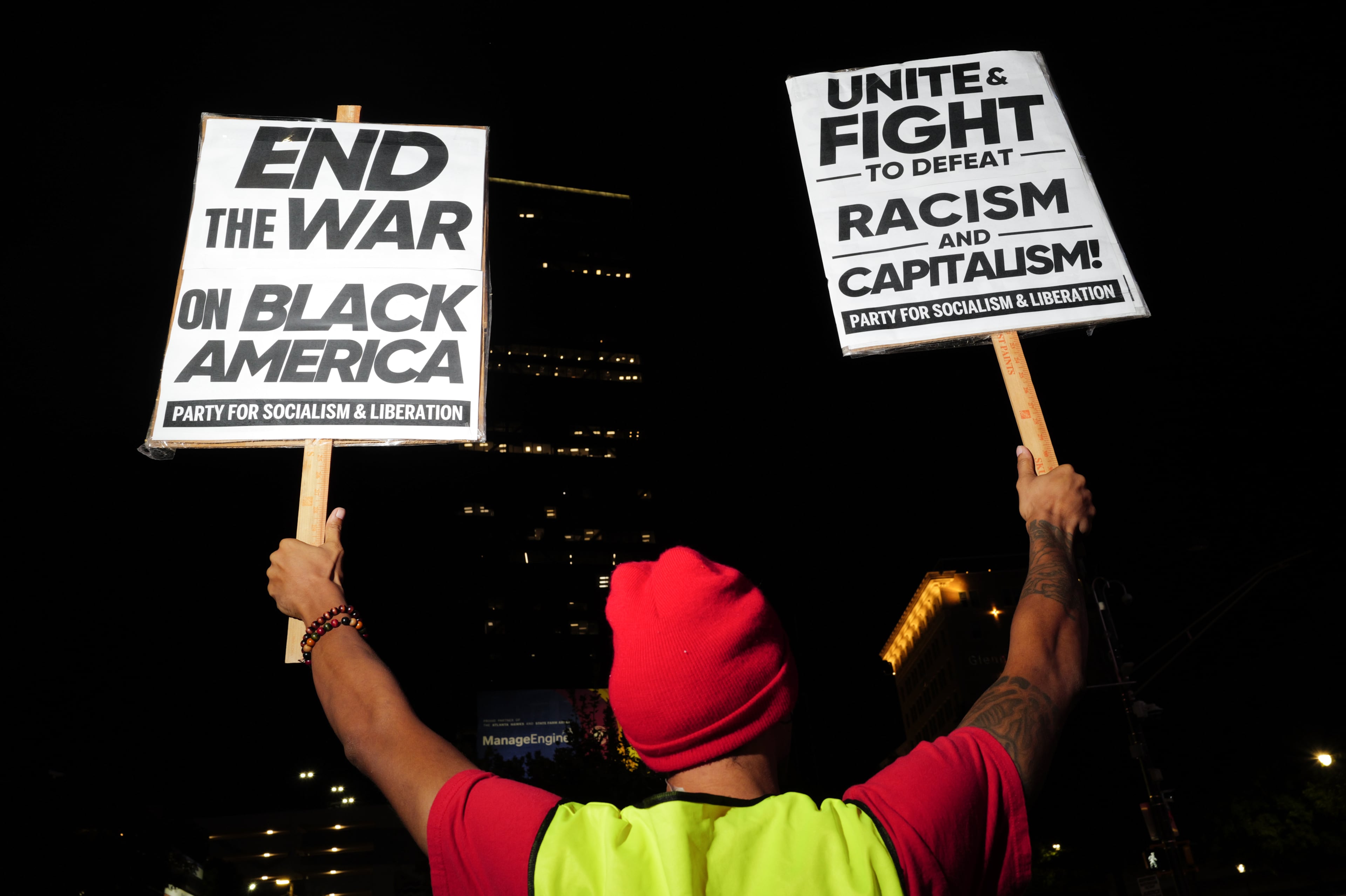 A protestor holds up signs demanding justice for Mississippi’s Nolan Wells outside Centennial Olympic Park in Atlanta on Oct. 6, 2026. (Arvin Temkar/AJC)