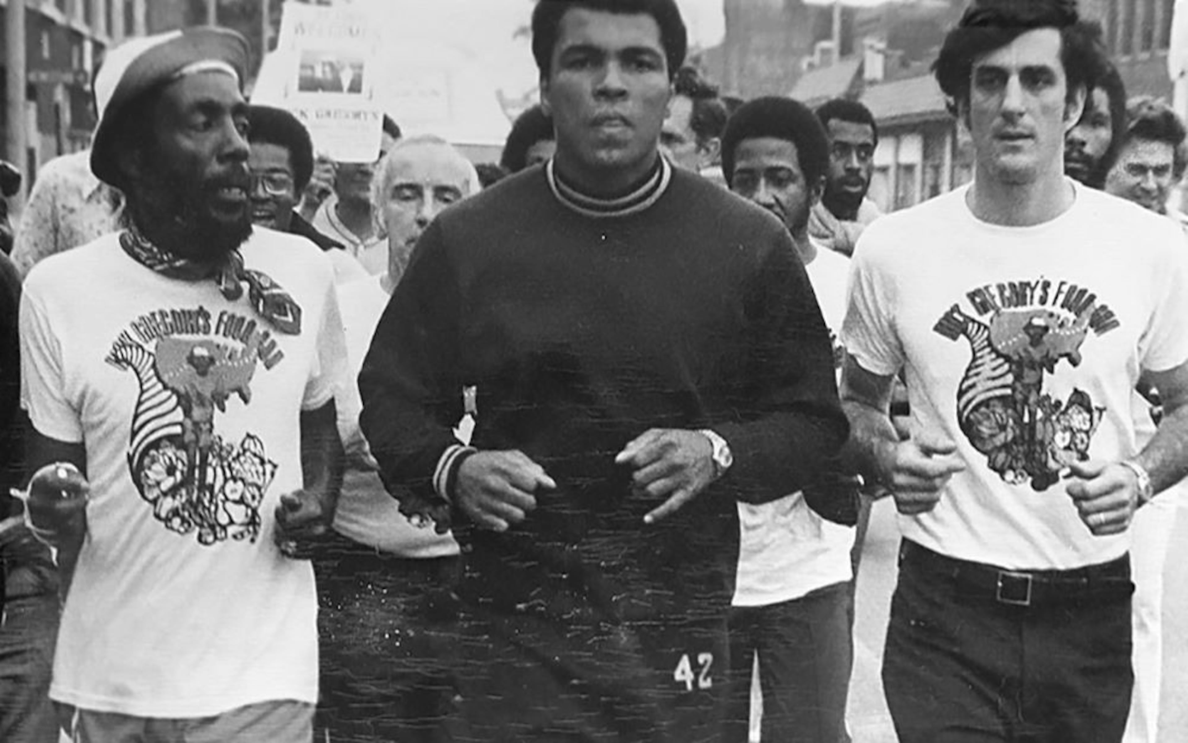 Comedian and activist Dick Gregory (left) was joined by boxer Muhammad Ali (middle) during his cross-country run for hunger in 1976. (Courtesy of Dick Gregory Media)