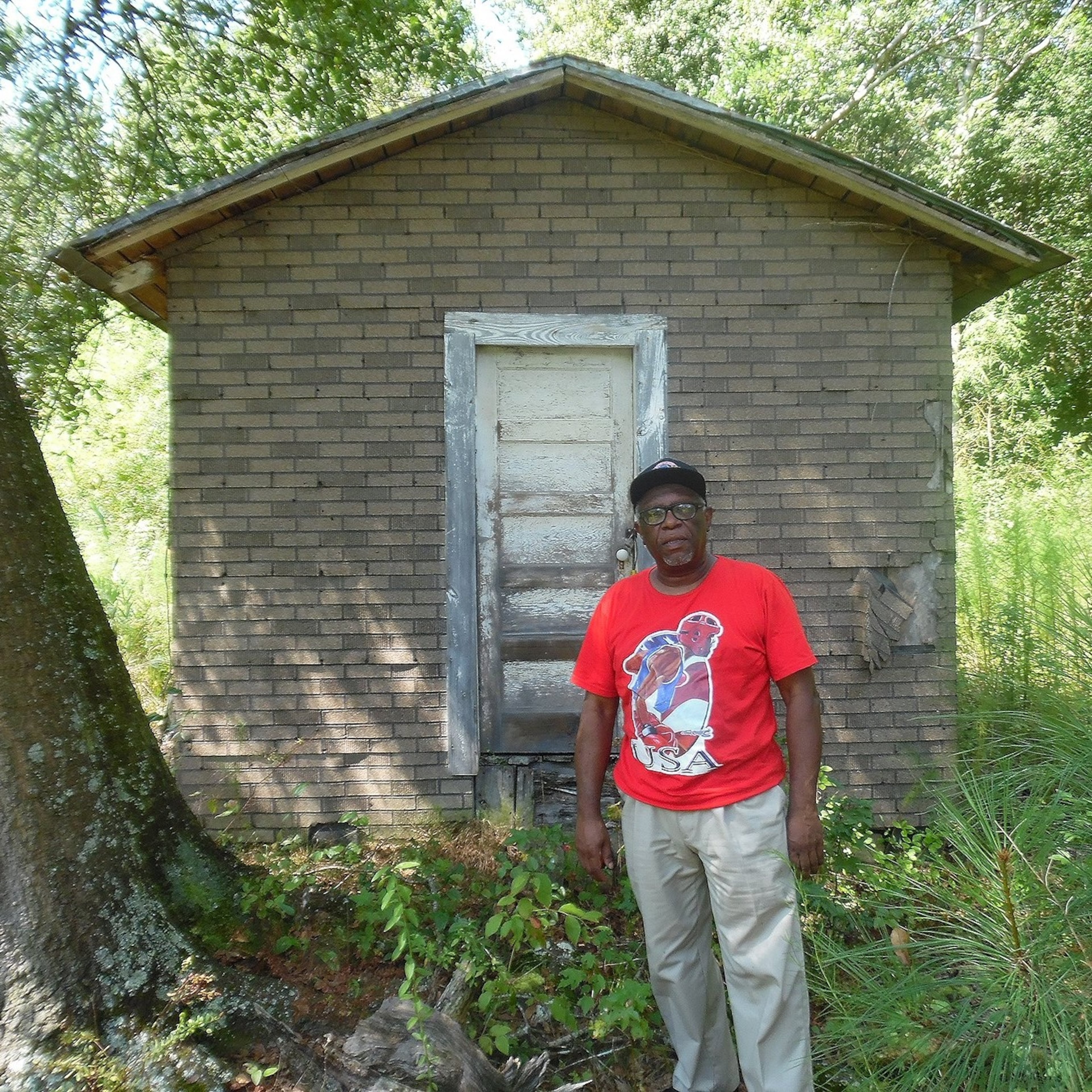 Atlanta-based artist Steve Allen stands in front of his one-room birth home in Norrington Crossroads, North Carolina, in 2016. Allen was born in 1954. (Courtesy of Steve Allen)