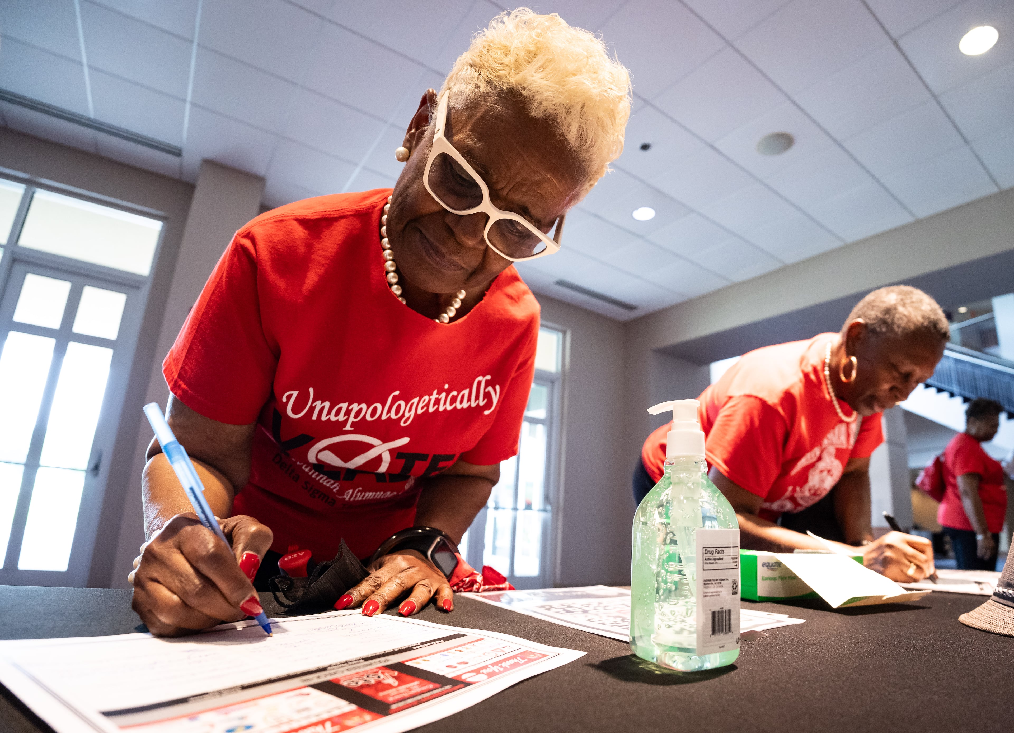 Elaine Shavers Campbell, president of the Savannah Alumnae Chapter of Delta Sigma Theta Sorority Inc., writes down her information to volunteer for a voter mobilization event at New Birth Missionary Baptist Church in Stonecrest in 2024. (Seeger Gray/AJC)