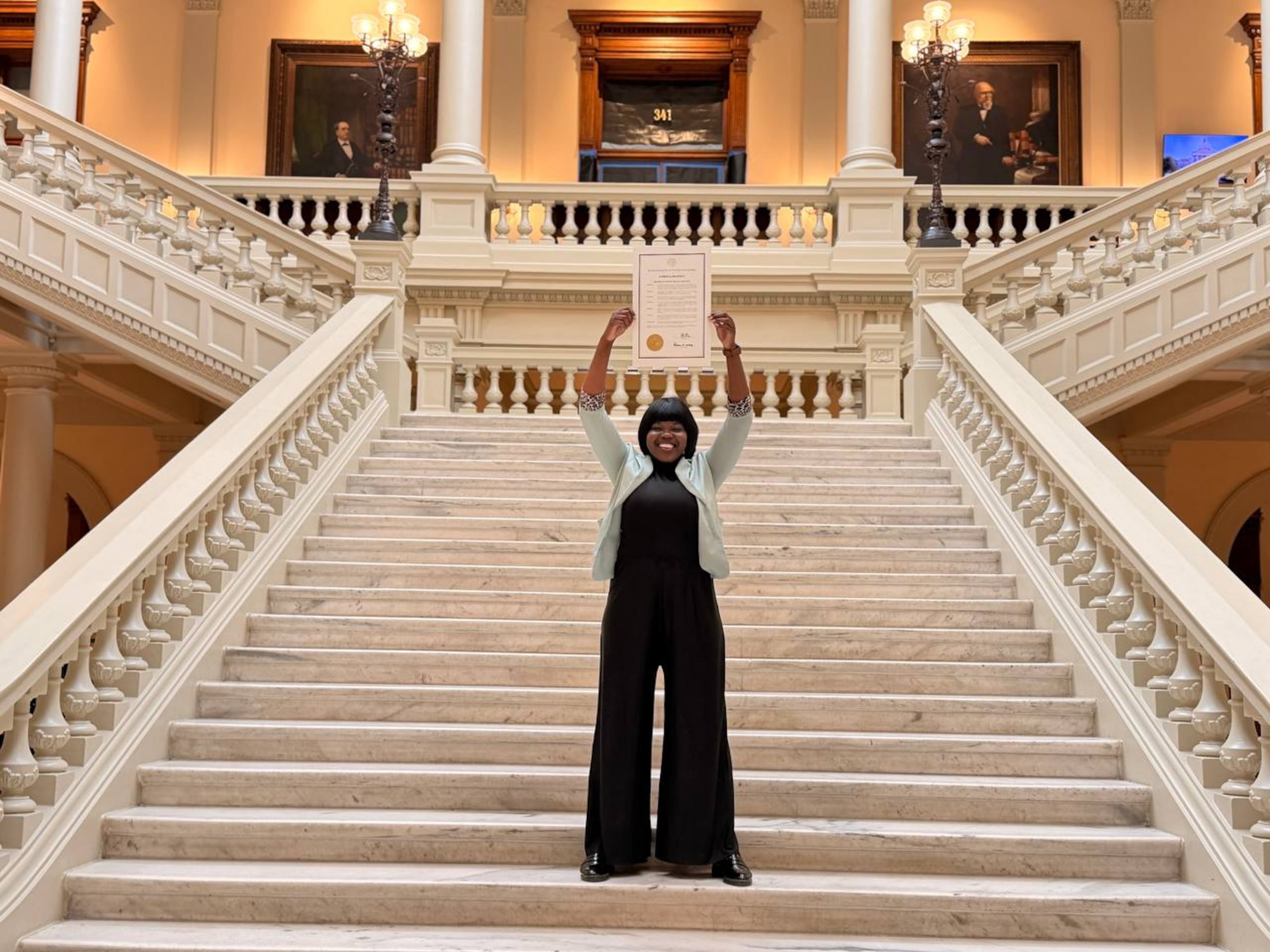 Chief Branch Manager of HWPL Georgia Kim Thomas holding the Georgia Proclamation of Peace in the Governor's Office. (Courtesy of HWPL Georgia)