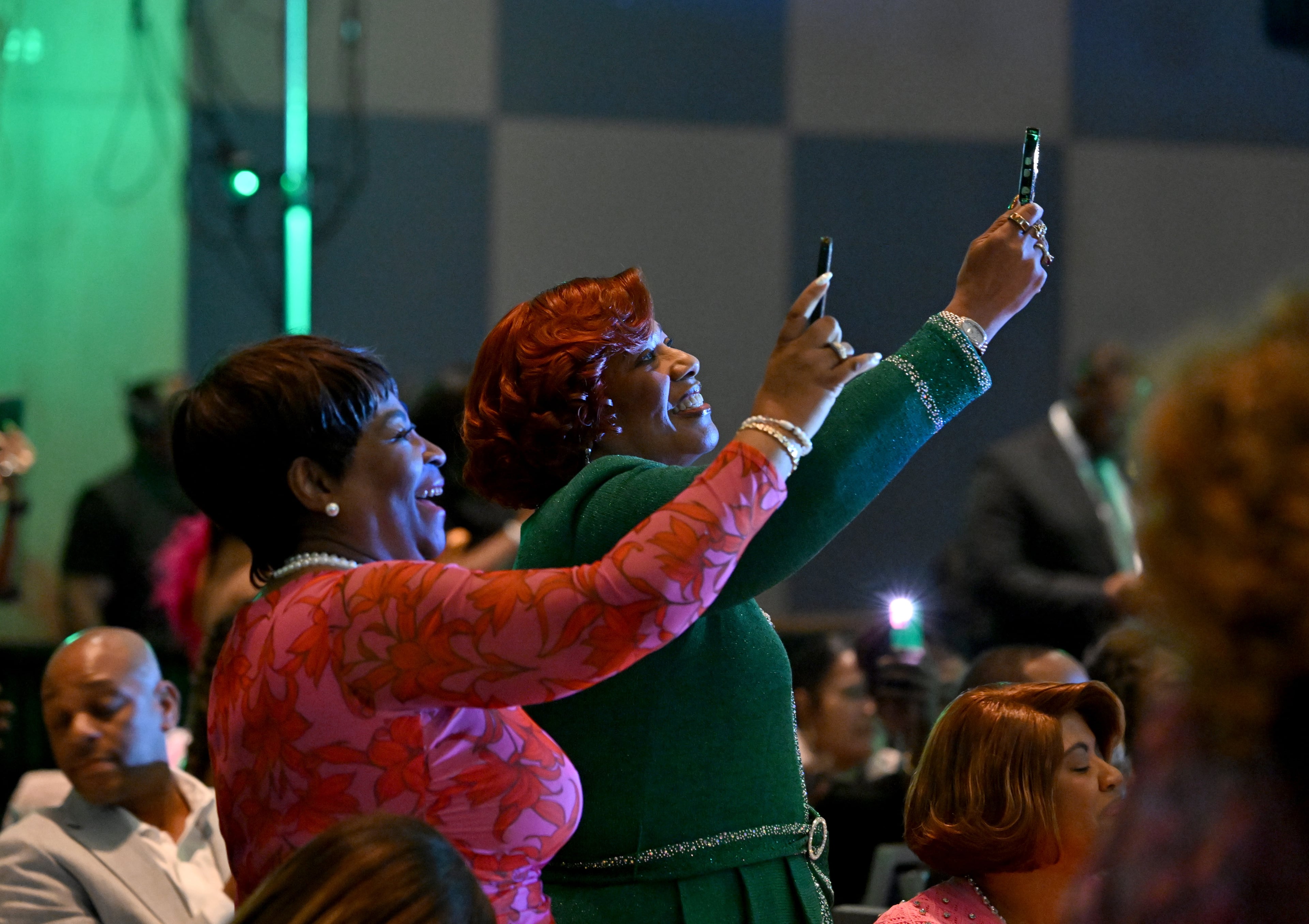 Bernice A. King, youngest daughter of Dr. Martin Luther King Jr., raises her smartphone to take photos during the 2026 Pink Cultured Pearls Cotillion. (Hyosub Shin/AJC)