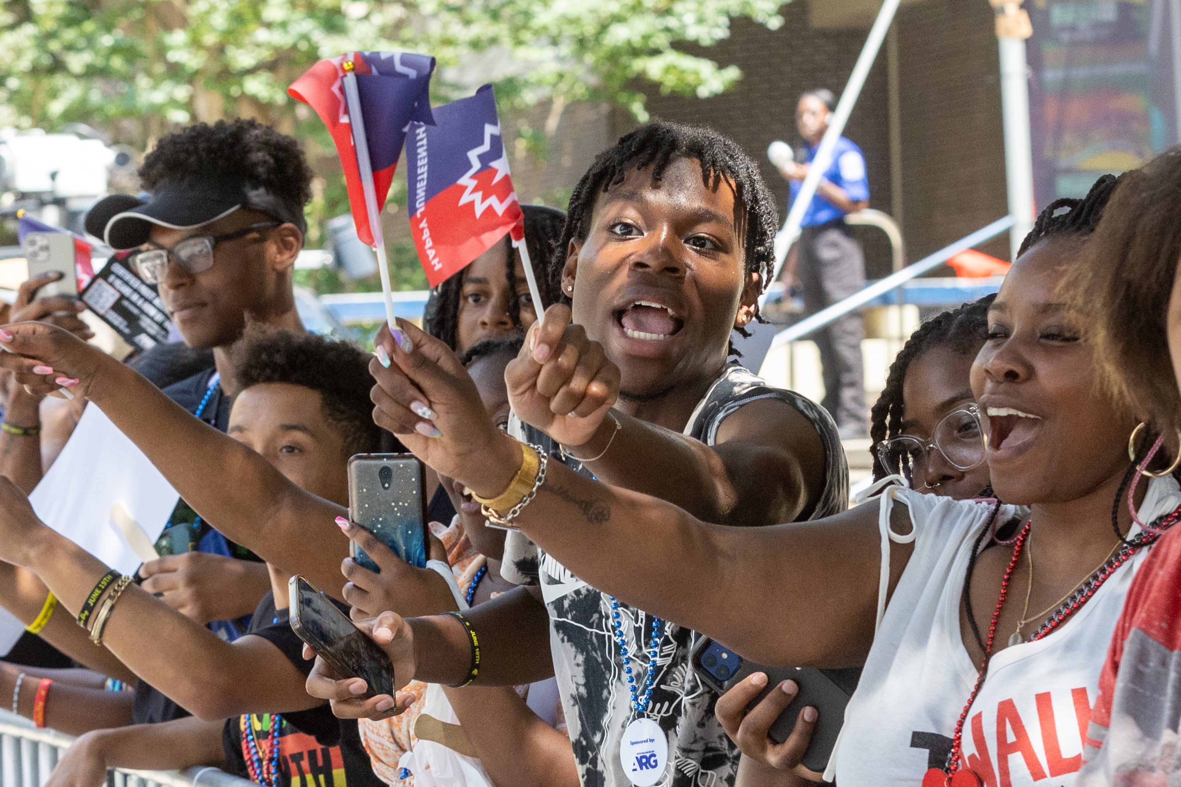 Chauncey Delaney (center) cheers on the parade as it moves up Decatur St. towards Centennial Park during the Juneteenth Atlanta Parade and Music Festival Saturday, June 17, 2023. (Steve Schaefer/AJC.com)