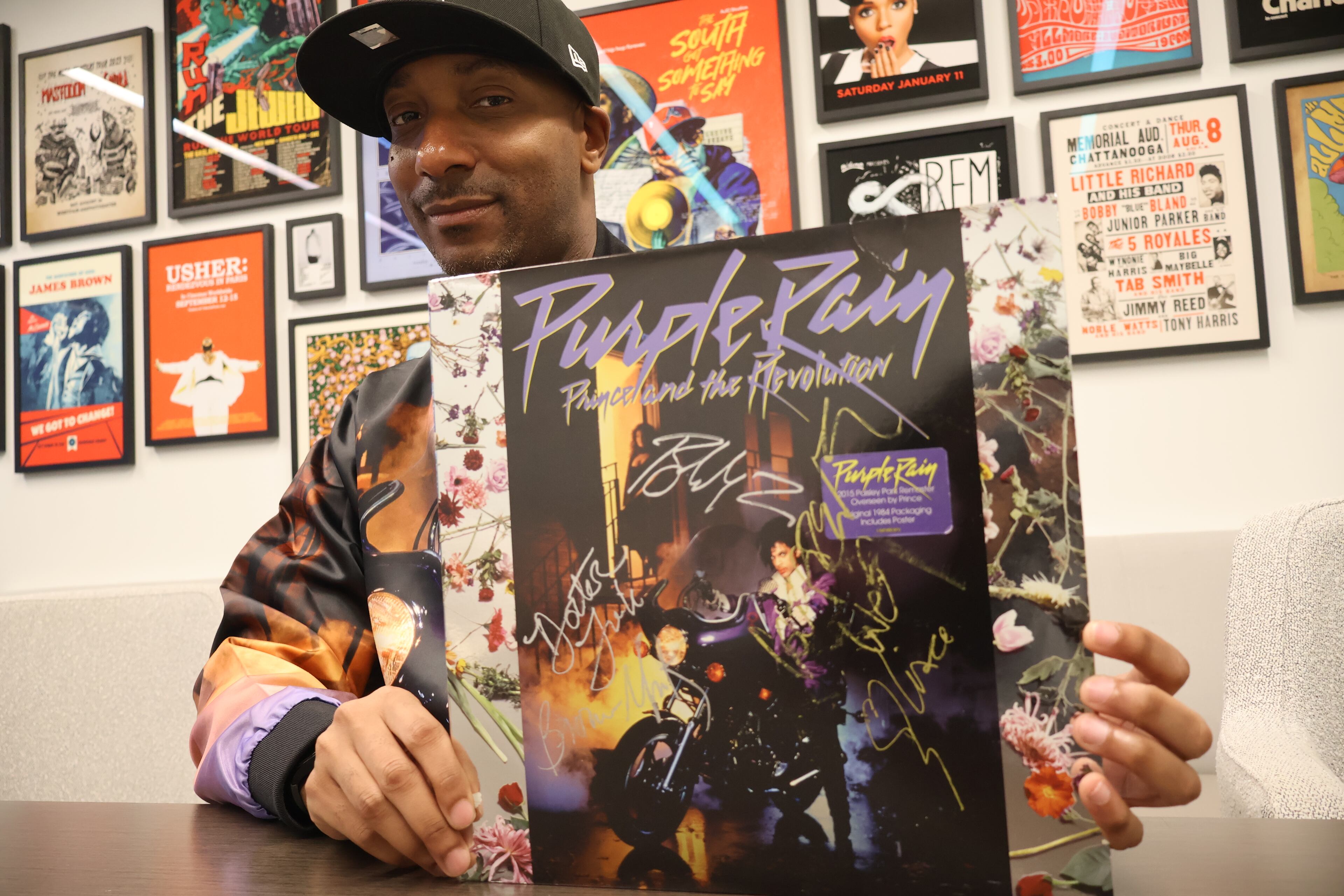 UATL Black culture reporter Christopher A. Daniel holds an autographed reissued copy of Prince and the Revolution's 1984 bestselling album "Purple Rain" at The Atlanta Journal-Constitution's Midtown office on July 21, 2026. (Courtesy of Kevin Pernell)