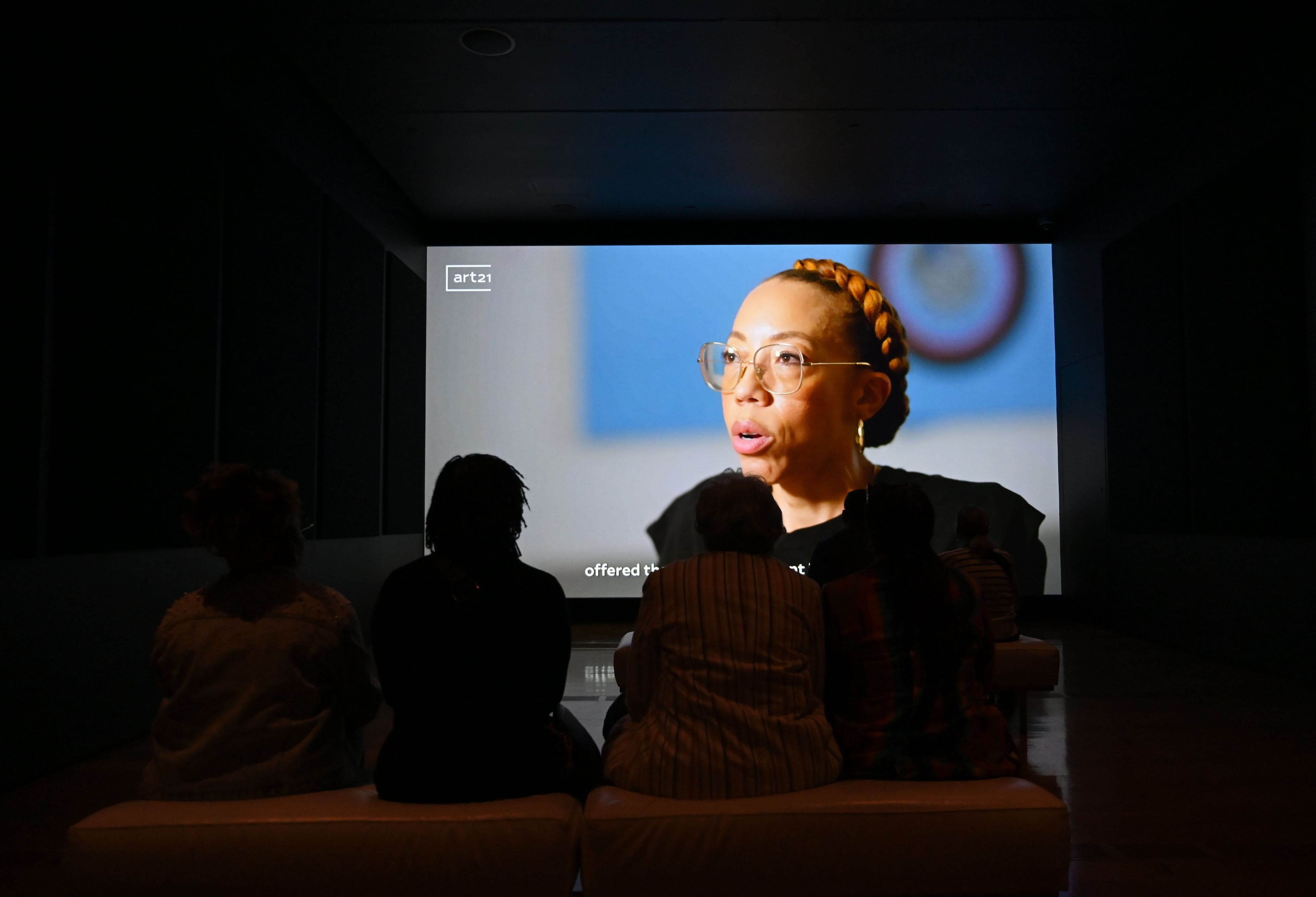 Visitors watch a documentary of Amy Sherald's life in the “American Sublime” exhibition at the High Museum of Art on Friday, May 15, 2026, in Atlanta. For painter Amy Sherald, the final stop of the national tour for “American Sublime”—the largest presentation of her work—feels like a homecoming. The exhibition opened at the High Museum of Art on Friday, May 15. (Hyosub Shin/AJC)
