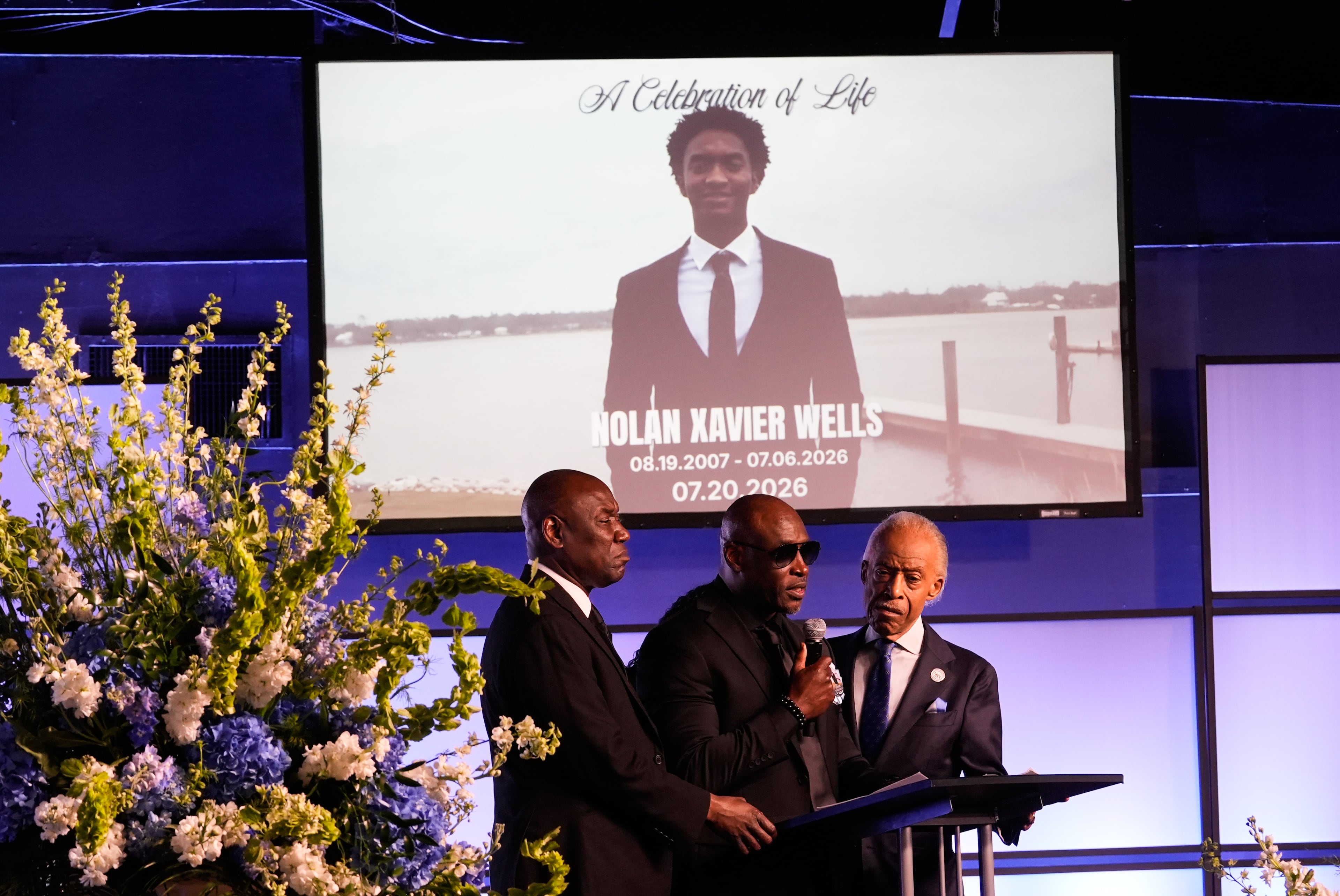 Elmore Wonsley, center, speaks next to attorney Ben Crump, left, and Rev. Al Sharpton during a memorial service for Nolan Xavier Wells, an 18-year-old found dead after taking a July 4 boat trip with friends, Monday, July 20, 2026, in Ocean Springs, Miss. (Gerald Herbert/AP)