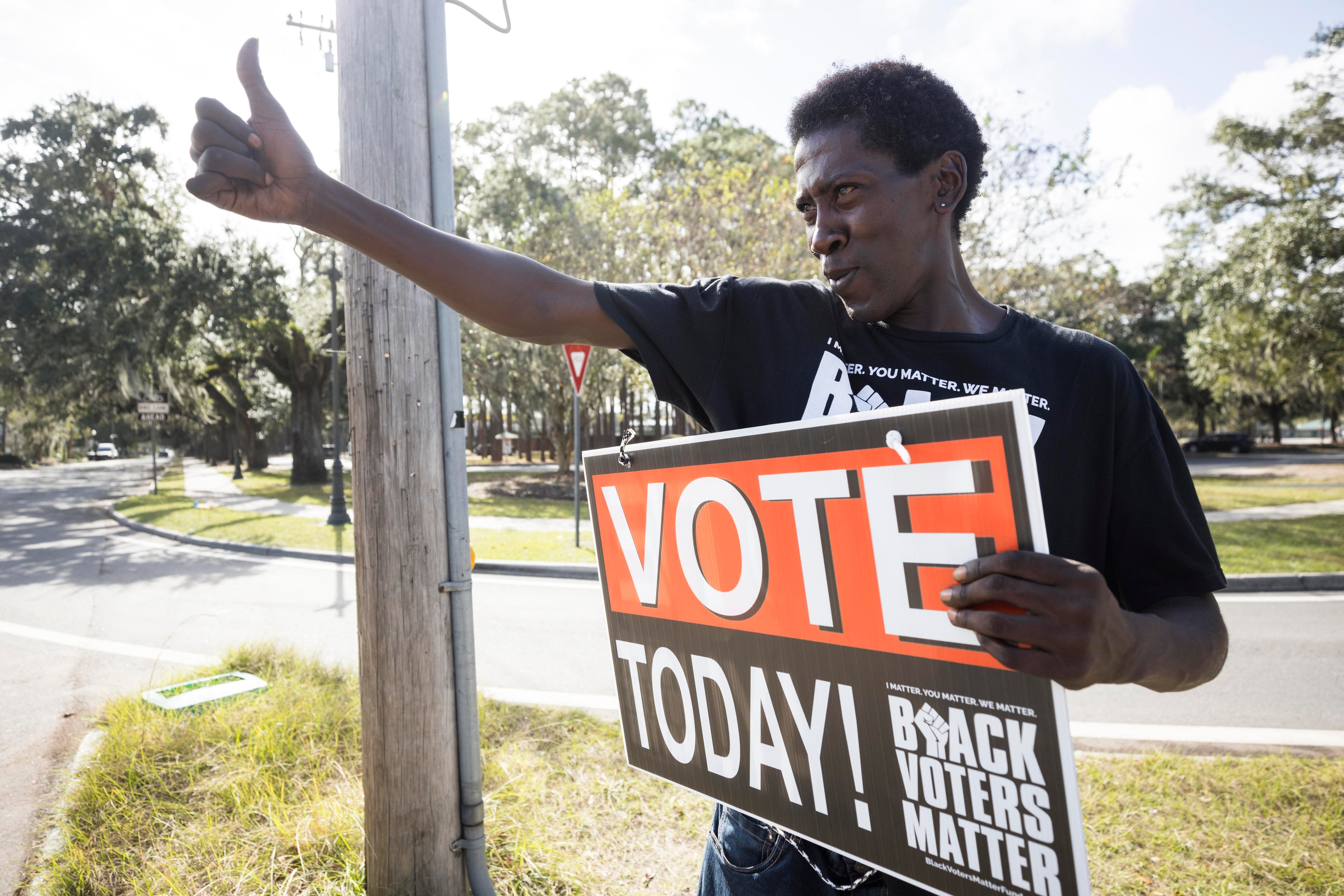 Savannah resident Daniel Scott encourages people to vote at a busy intersection, Tuesday, Nov. 5, 2024, in Savannah, Ga. (Stephen B. Morton/AJC)