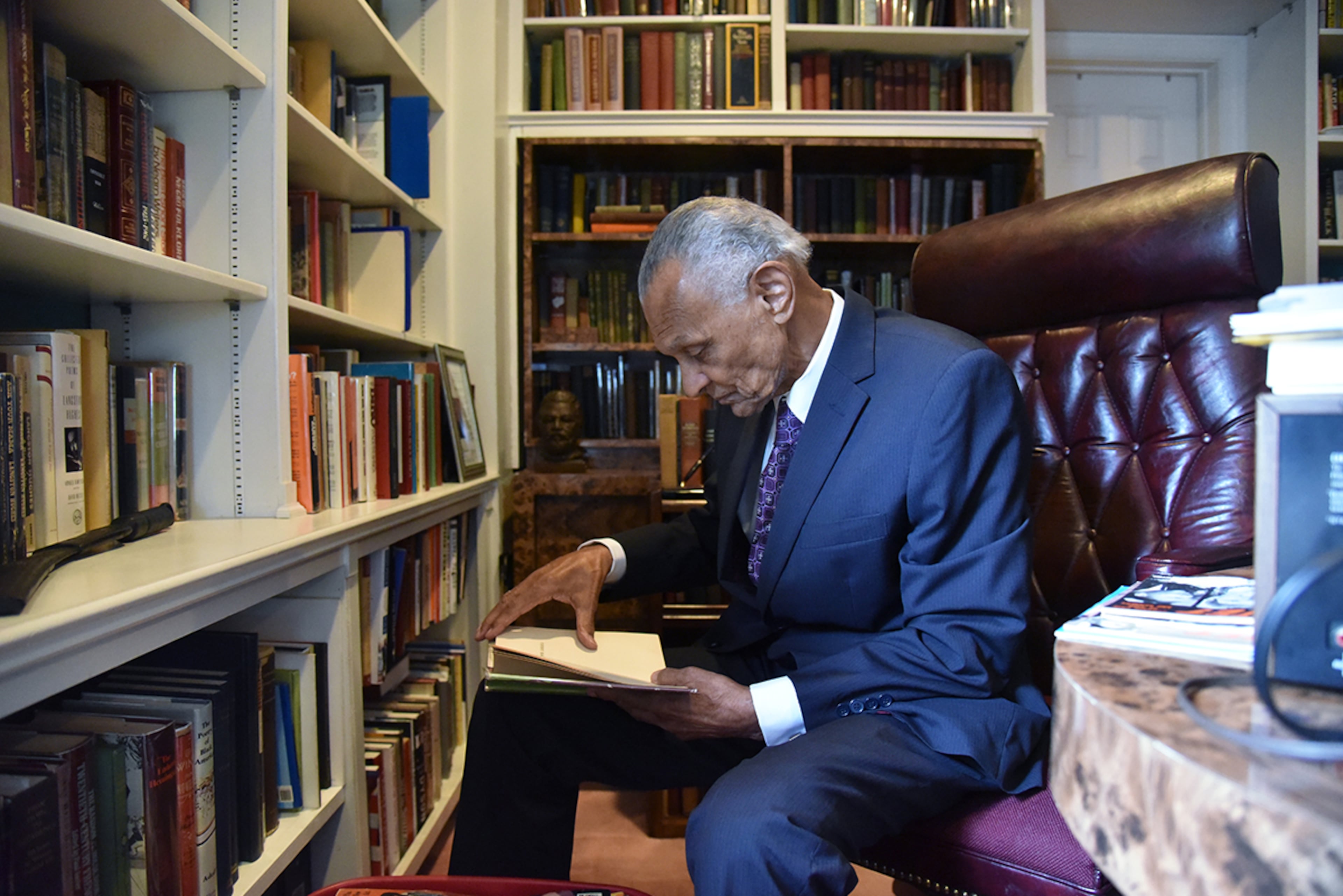 The Rev. C.T. Vivian, pictured looking through a book at his home library in 2017, donated his collection of more than 6,000 books to the National Monuments Foundation. (Hyosub Shin/AJC 2017)